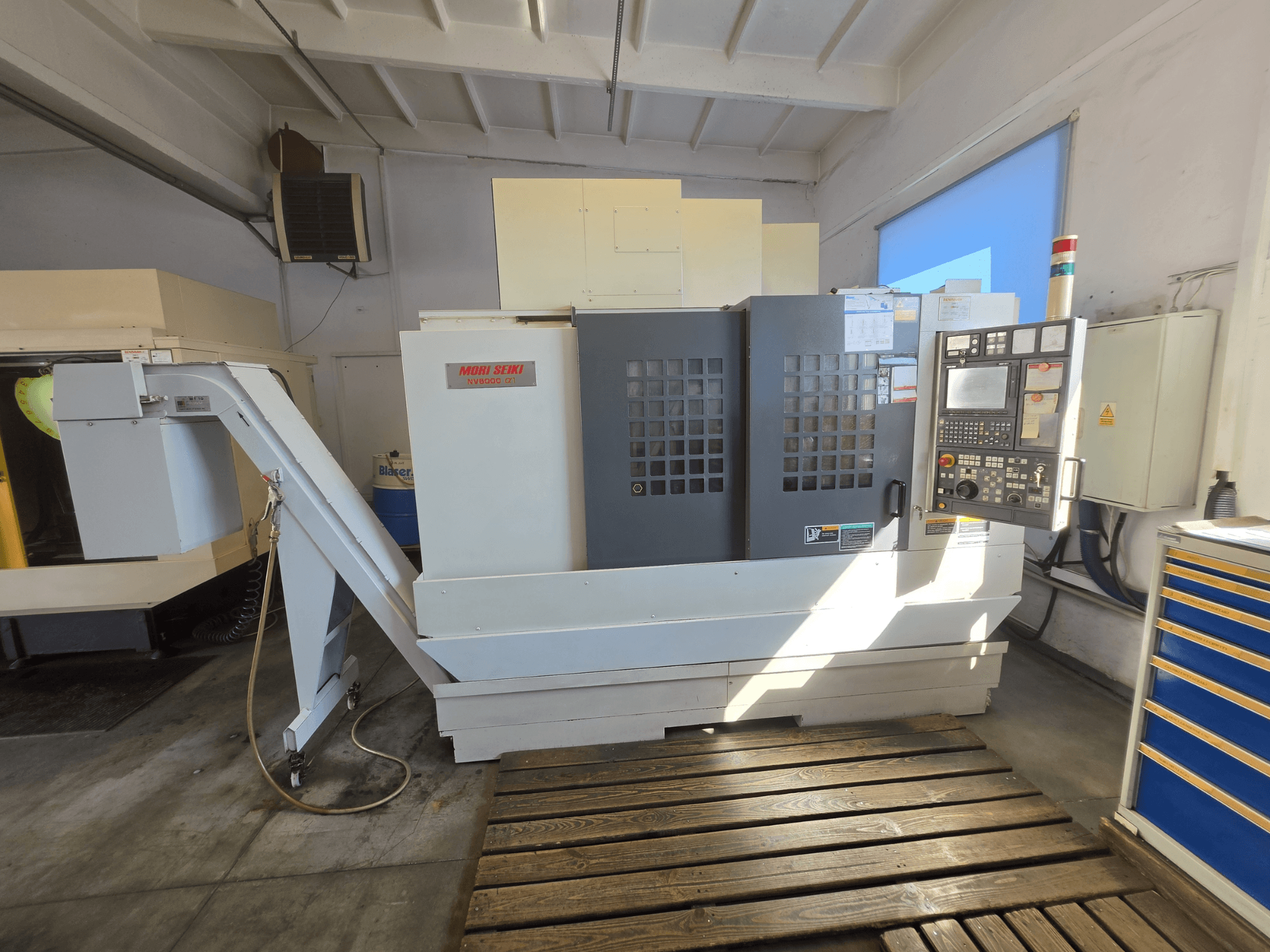 Vertikales Bearbeitungszentrum MORI SEIKI NV 5000 alpha1, Vorderansicht mit Bedienfeld und Maschinenausstattungsmerkmalen in einer Werkstattumgebung.
