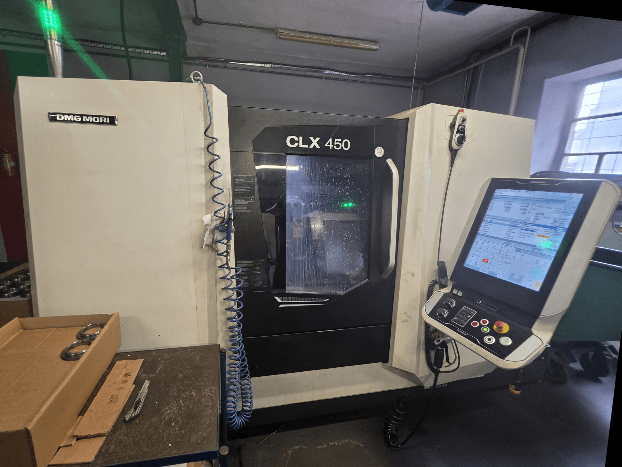 Frontansicht der Horizontal-Drehmaschine DMG MORI CLX 450 V3 mit Bedienfeld, Kühlmittelsystem und Arbeitsbereich.