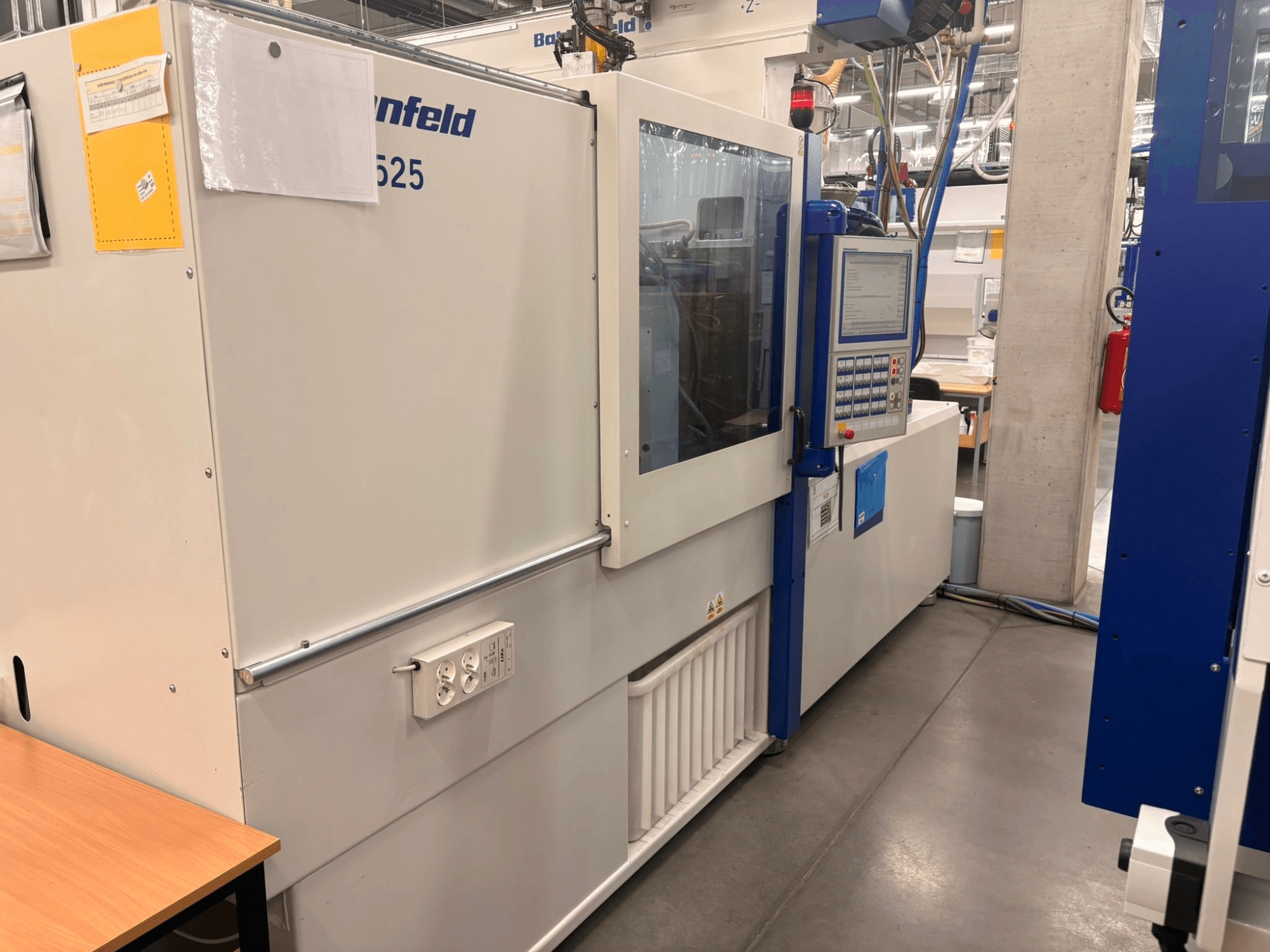 Maschinen von Arburg, Modell 620S, Frontansicht mit Bedienfeld und Stromanschlüssen in einer Fabrikumgebung.