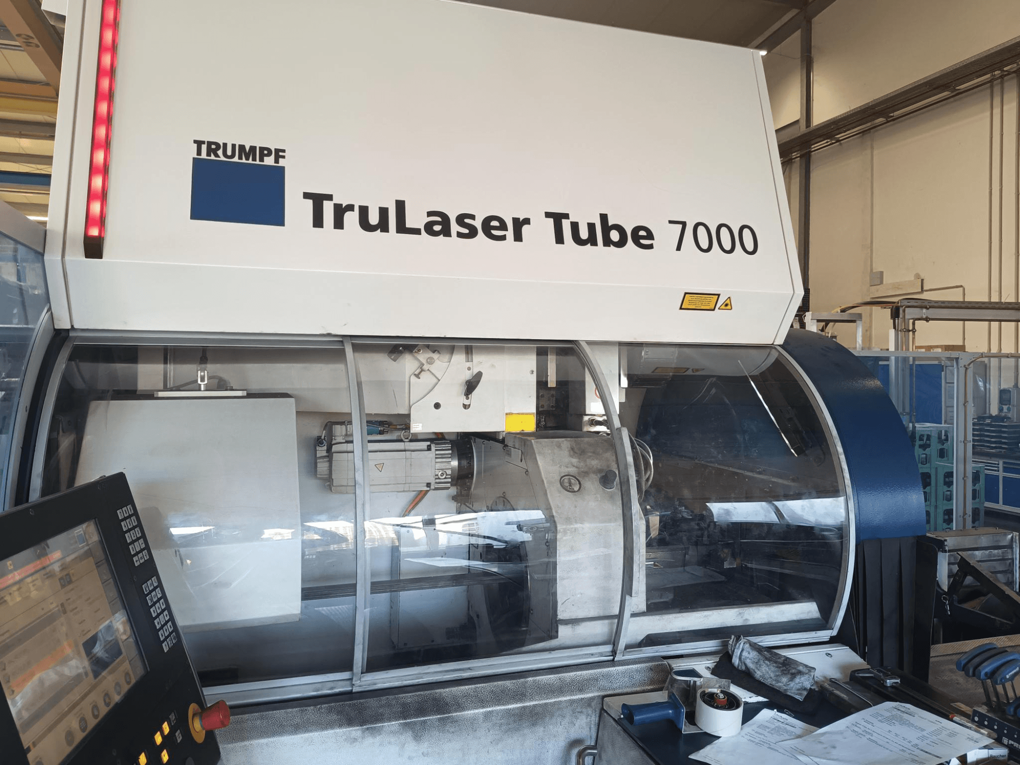 TRUMPF TruLaser Tube 7000, Frontansicht der Maschine mit Bedienfeld, Darstellung der Laserschneidfunktionen und des Arbeitsbereichs.