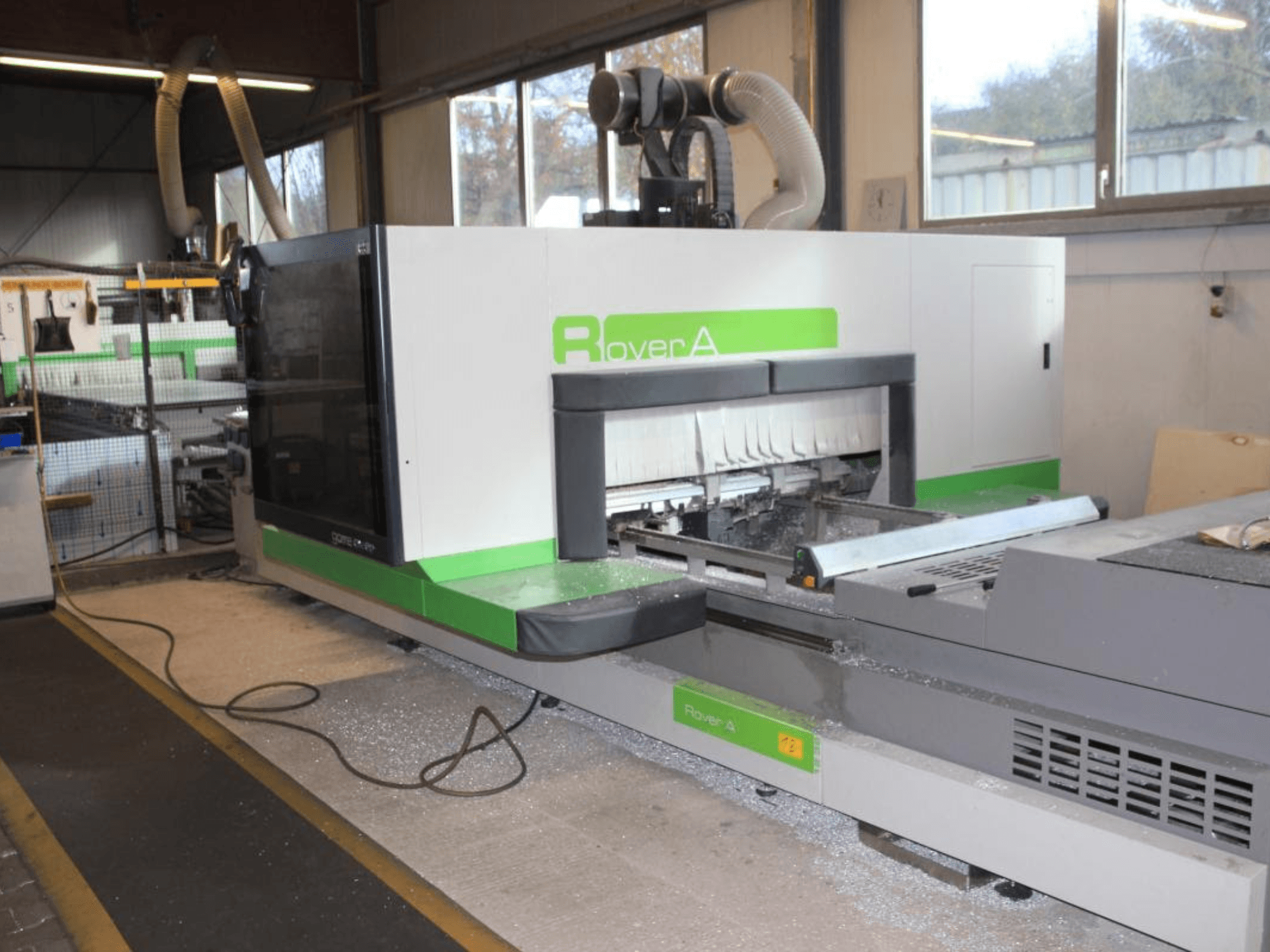 BIESSE Rover A 1232 CNC-Oberfräse, Seitenansicht mit Schnittbereich und Bedienfeld in einer industriellen Umgebung.