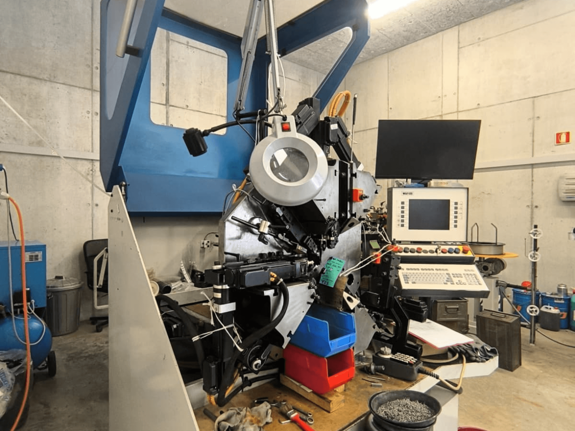 Die WAFIOS Fmu1-Blechbearbeitungsmaschine in Frontansicht, mit Darstellung der Bedienelemente und Komponenten, eingebettet in eine industrielle Arbeitsumgebung.