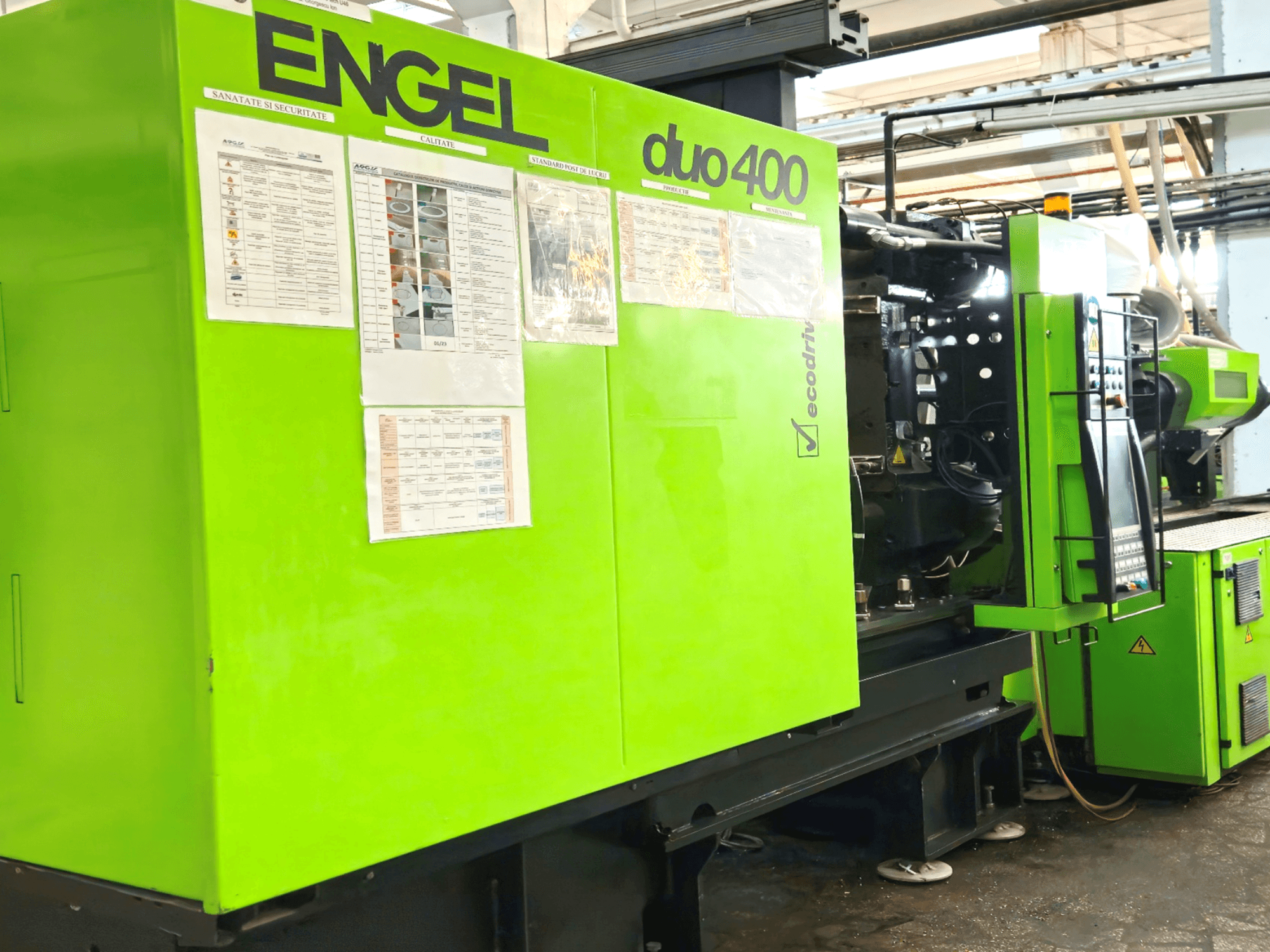 Grüne ENGEL duo 400-Spritzgießmaschine, Frontansicht, mit Bedienfeld und Sicherheitsdokumentation auf der Außenseite.