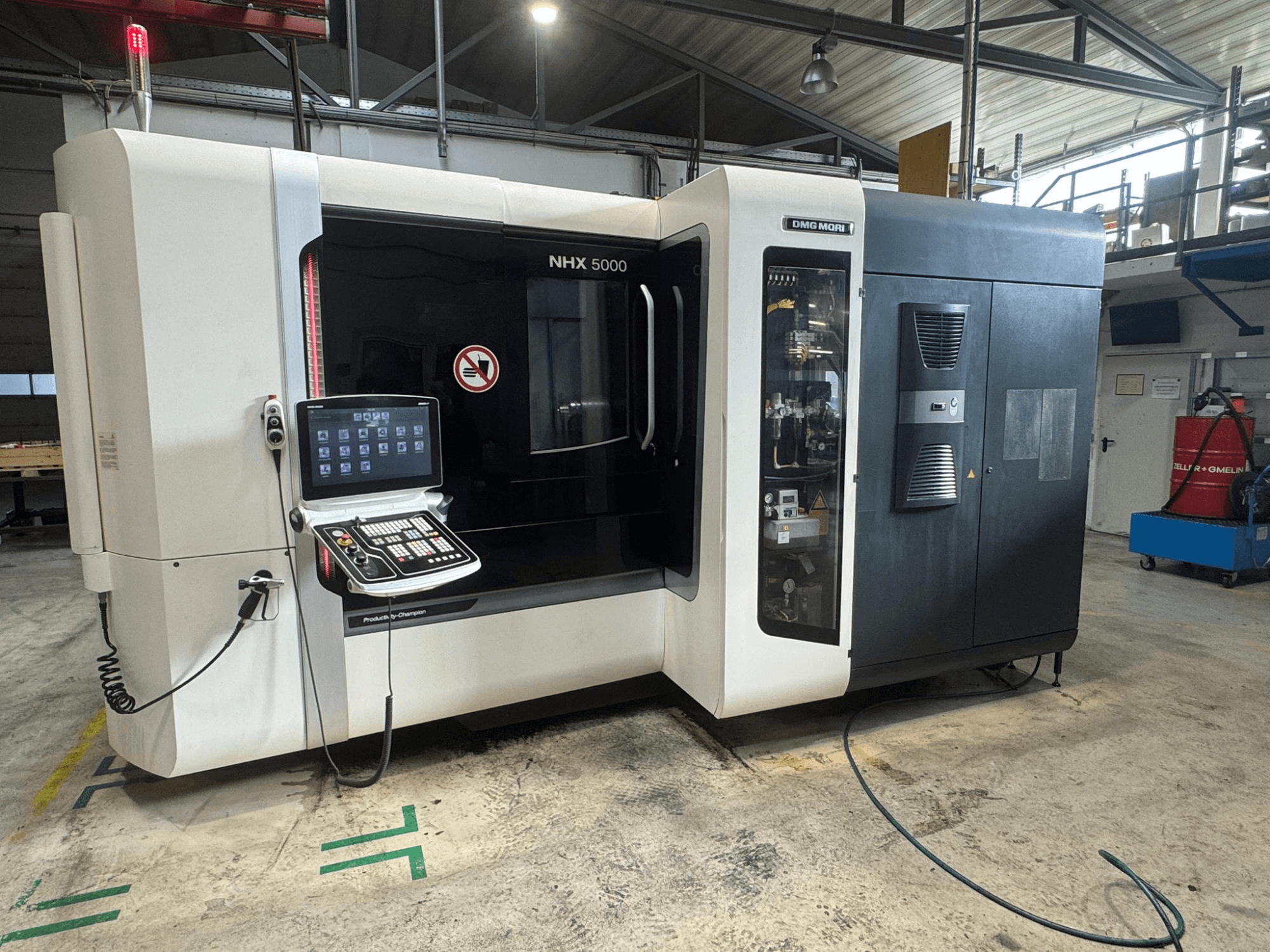 DMG MORI NHX 5000 horizontales Bearbeitungszentrum, Frontansicht mit sichtbarem Bedienfeld und Sicherheitsanzeigen.