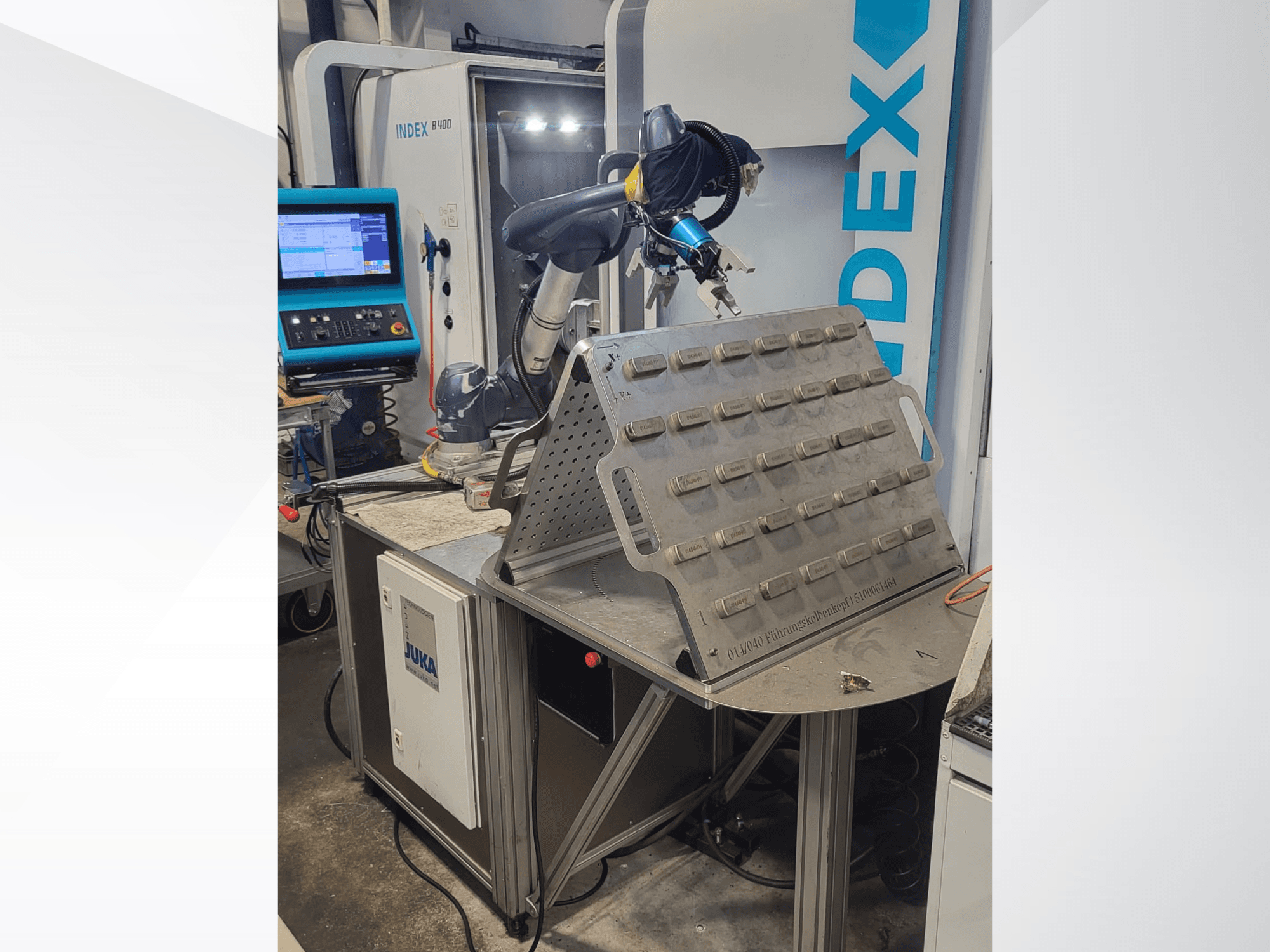 Der kollaborative Roboter DOOSAN M1013 in der Vorderansicht, positioniert in der Nähe eines Arbeitstisches mit einem Werkzeughalter und einem Bedienfeld.