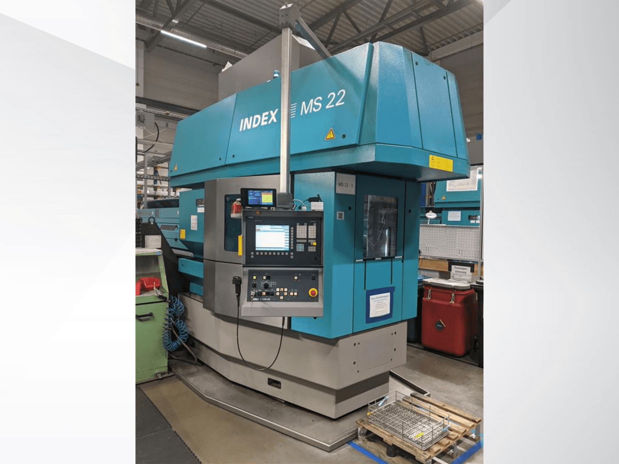 Mehrspindel-Drehmaschine Index MS 22 in einer Fabrikumgebung, Vorderansicht mit Bedienfeld und blauer Außenverkleidung.