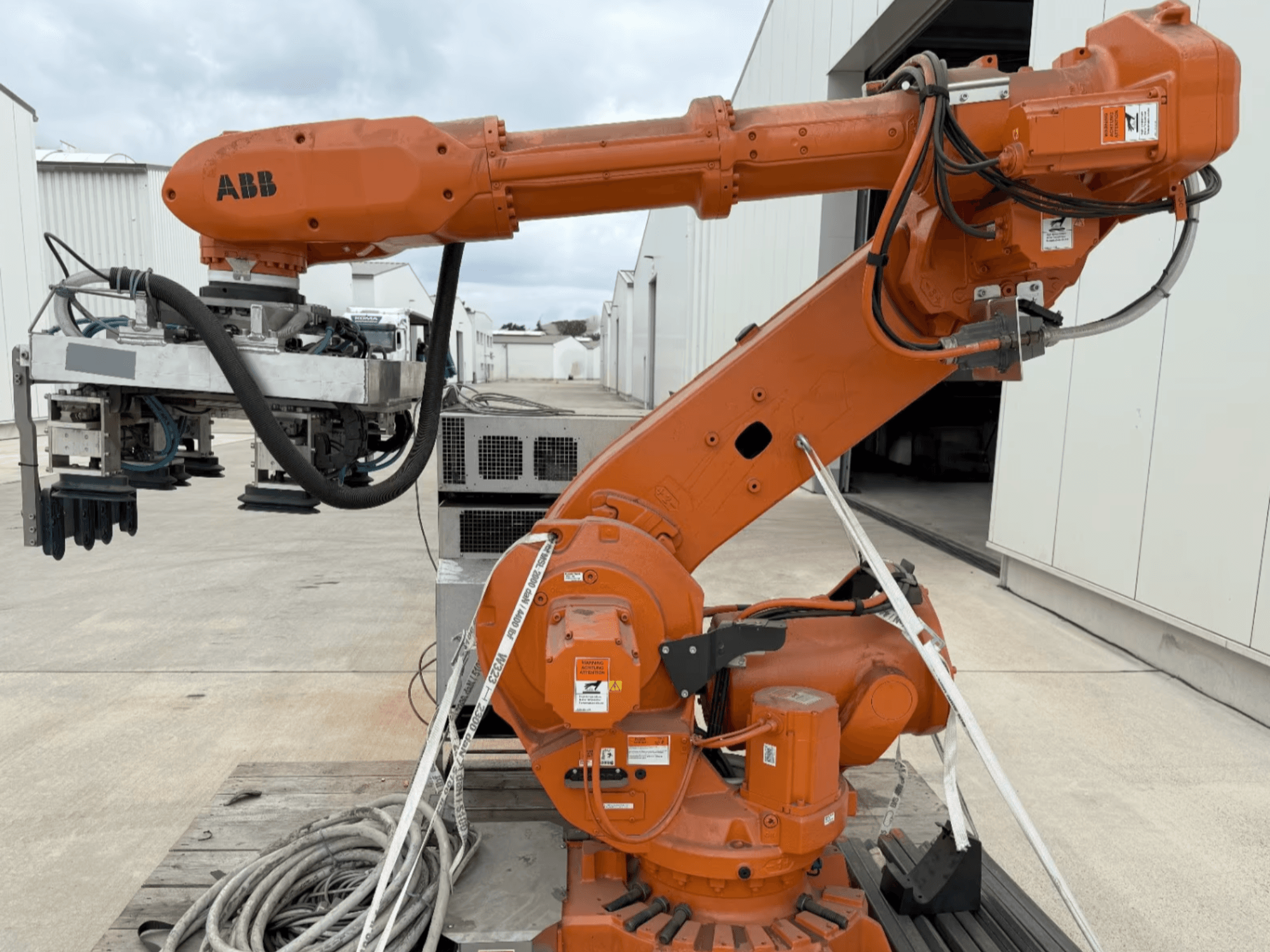 ABB RB 6600-130/3.2 Roboterarm in der Seitenansicht, mit einem orangefarbenen Roboterarm mit Greifvorrichtung und sichtbarer Verkabelung.