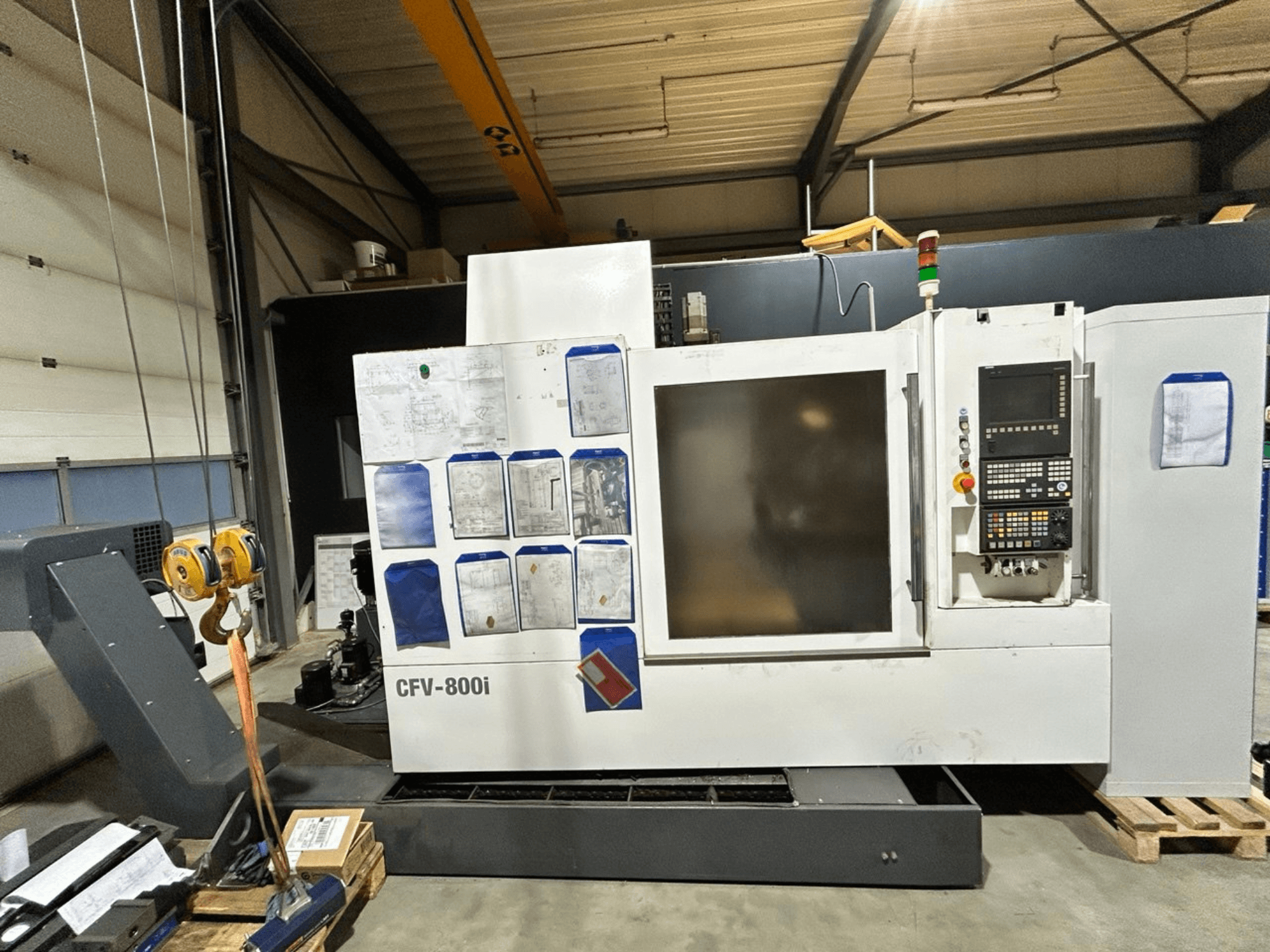 CFV-800i CNC-Maschine in Vorderansicht, mit Bedienfeld, seitlichen Unterlagen und Brückenkran in Werkseinstellung.