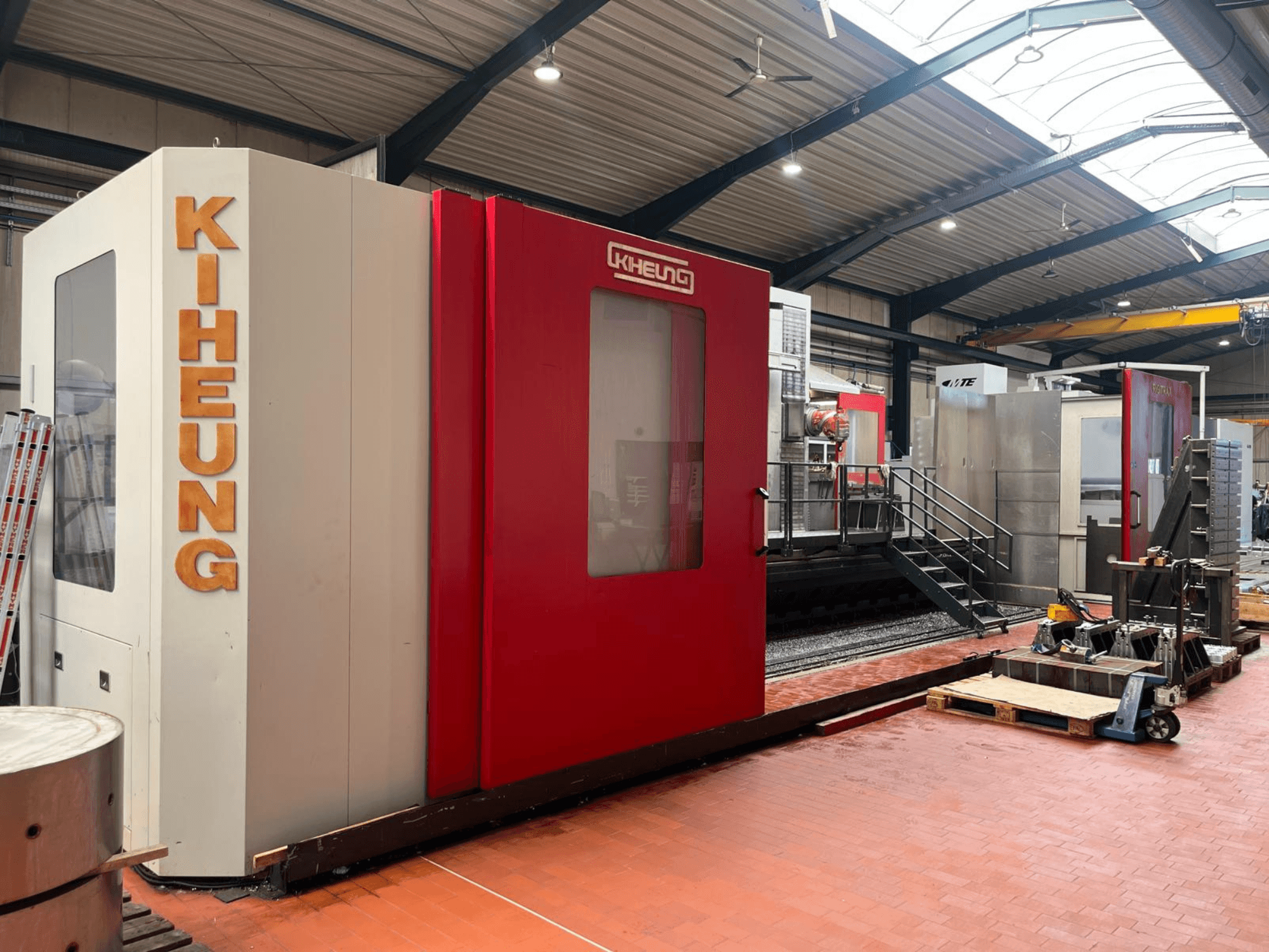 KIHEUNG RIGITRAX X 8000 Bettfräsmaschine in einer Werkstatt, Frontansicht mit rot-weißer Verkleidung.