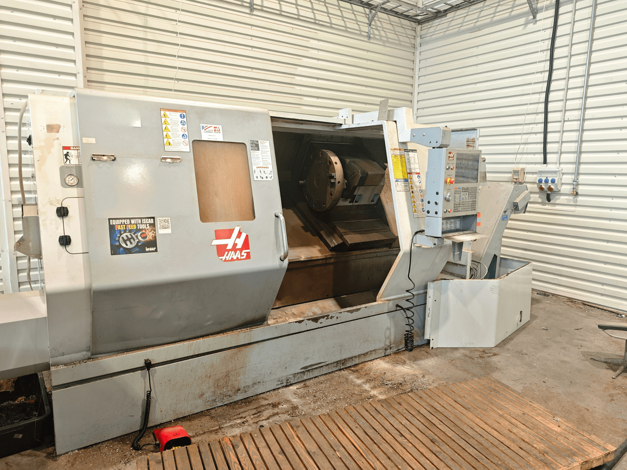 Horizontaldrehmaschine Haas SL-40HE, Vorderansicht, mit Blick auf das Bedienfeld, den Arbeitsbereich und die Sicherheitshinweise.