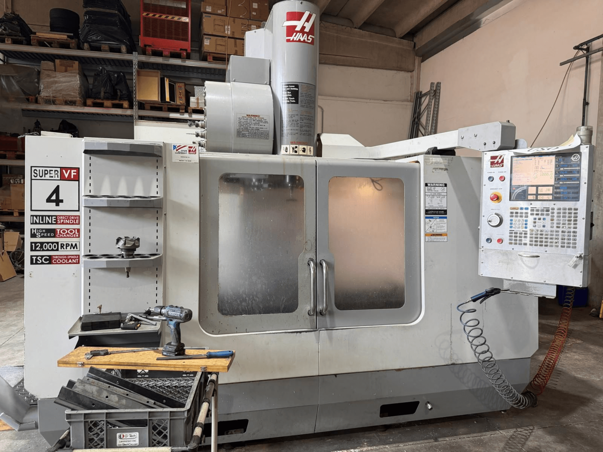Vorderansicht des vertikalen Bearbeitungszentrums HAAS VF-4SSHE mit Steuerung, Werkzeugmagazin und einer Spindel mit 12.000 U/min; eine hochgeschwindigkeitsfähige Präzisionsmaschine.