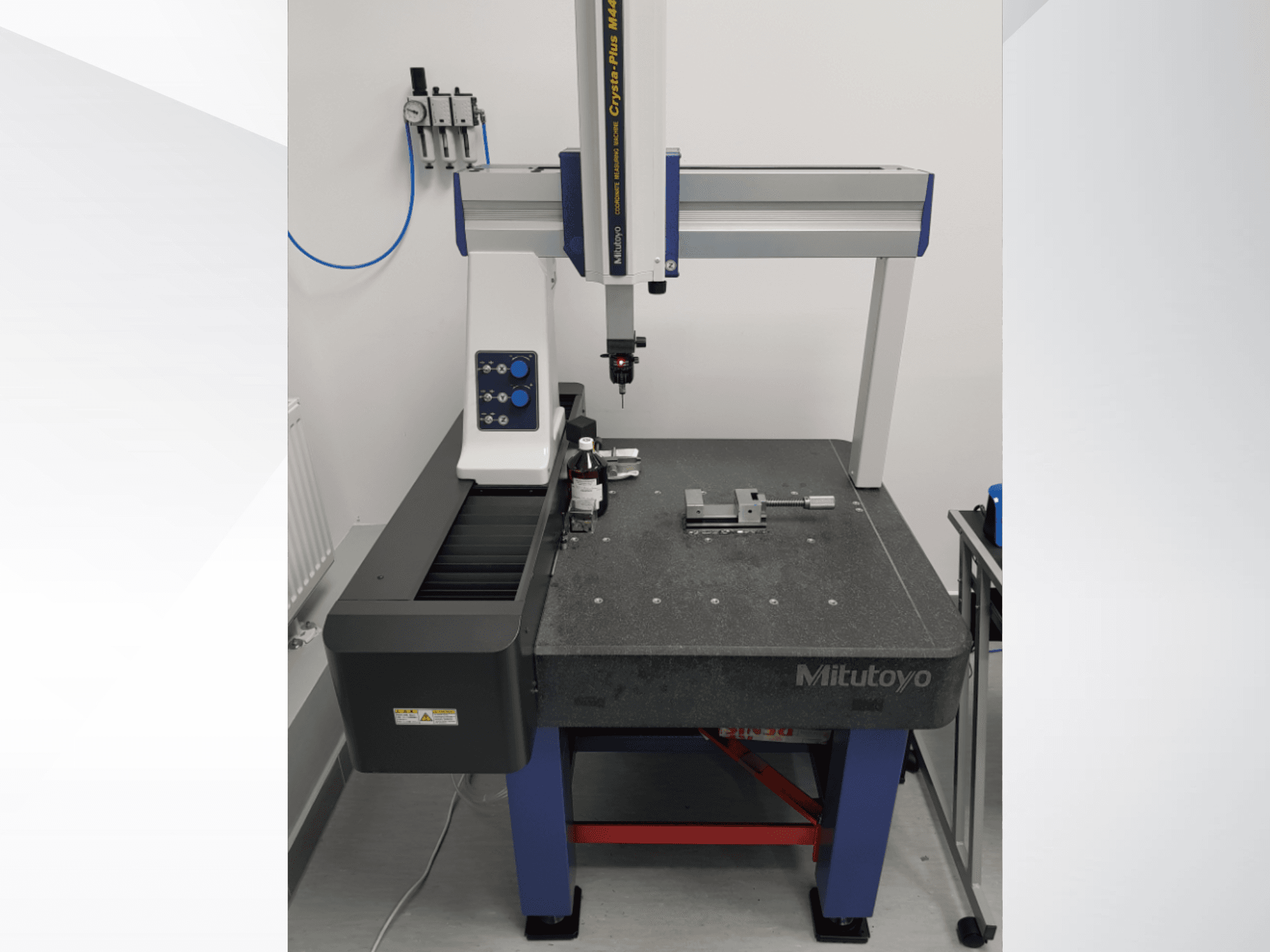Mitutoyo Crysta-Plus M443 CMM in der Vorderansicht, mit Messtaster, Bedienfeld und Prüftisch mit Halterungen.