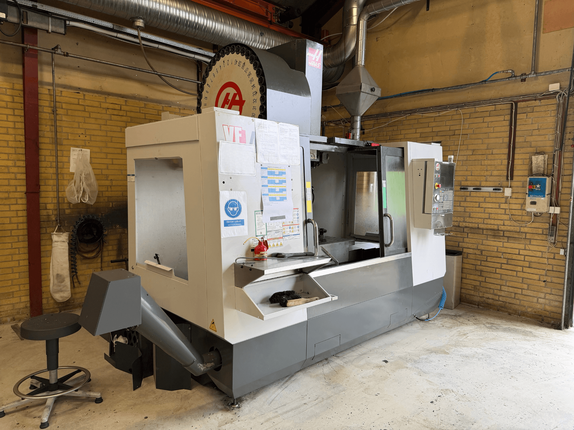 Vertikales Bearbeitungszentrum HAAS VF-4, Vorderansicht; im Vordergrund sind das Bedienfeld und der Werkzeughalter zu sehen, im Hintergrund die Fertigungsanlage.