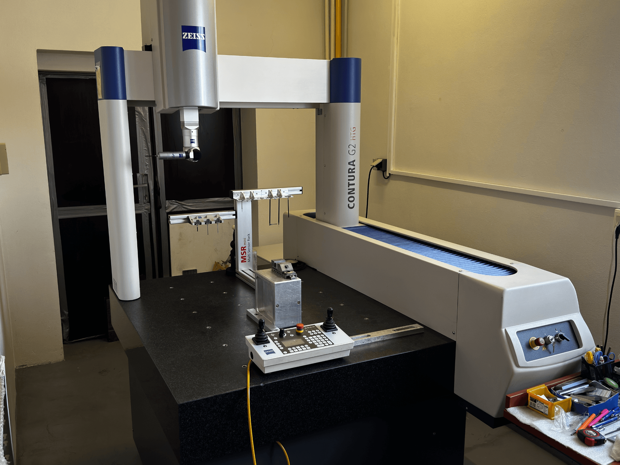 ZEISS Contura G2 KMG in einer Laborumgebung, Vorderansicht mit Messarm, Bedienfeld und angrenzendem Arbeitsbereich.