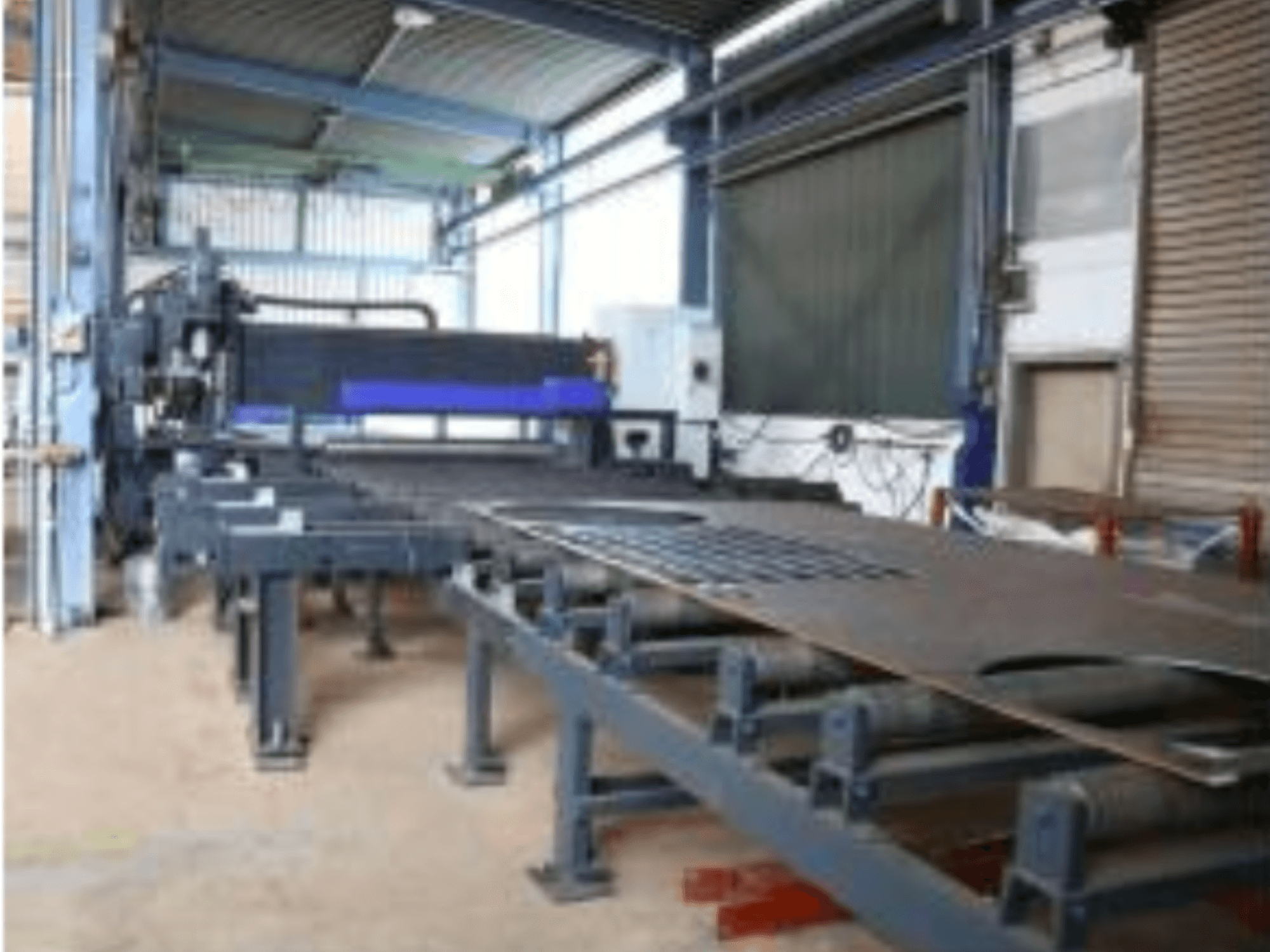 Behringer MAG EVO 420 Blechbearbeitungsmaschine in einer Werkstatt, Seitenansicht mit Förderband und Schneidbereich.
