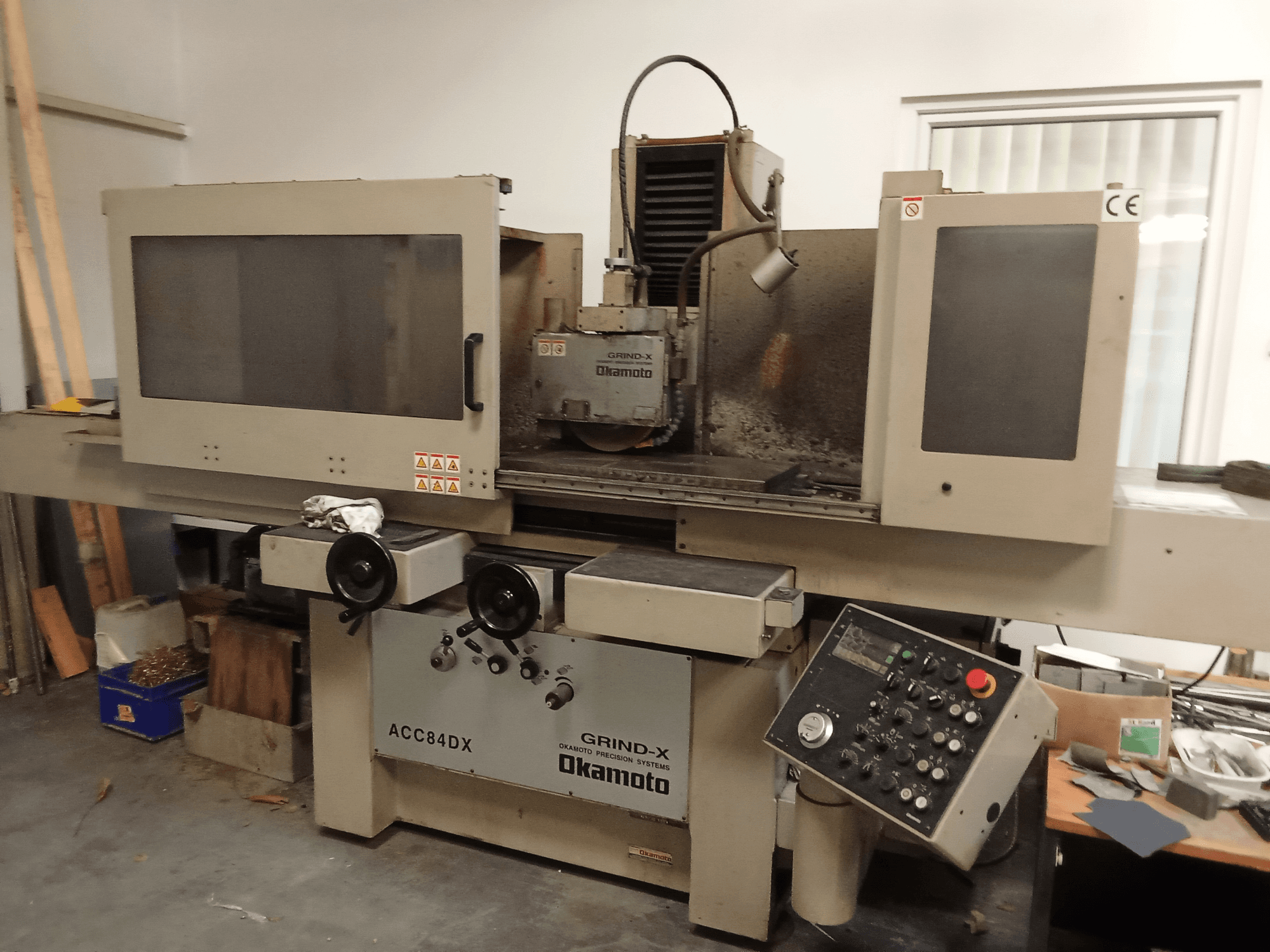 Vorderansicht der Flachschleifmaschine OKAMOTO ACC84 DX mit Bedienfeld und Schleifscheibenhaube.