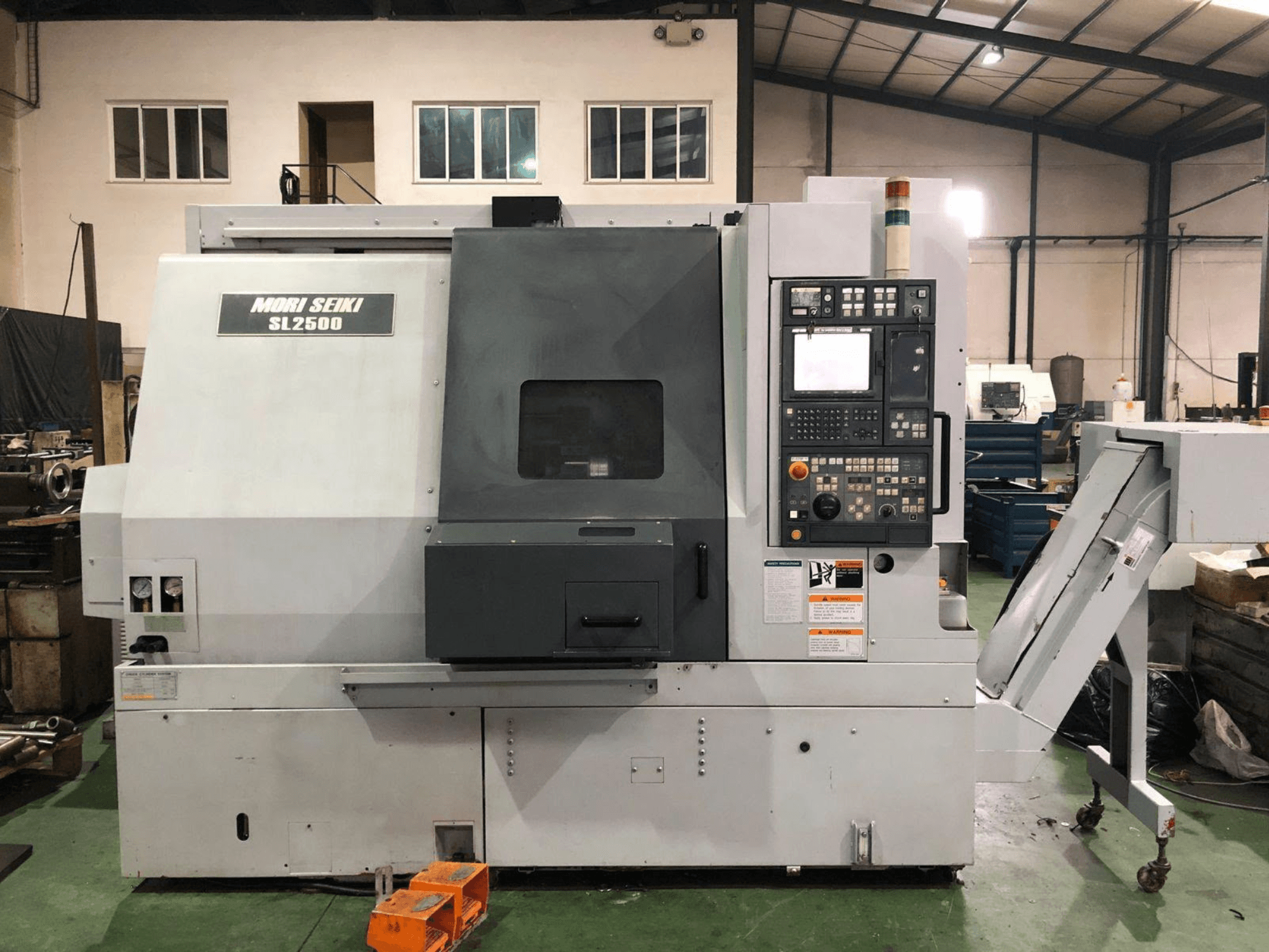 DMG Mori Seiki SL 2500 Y Dreh-Fräszentrum, Seitenansicht mit sichtbarem Bedienfeld und Späneförderer.