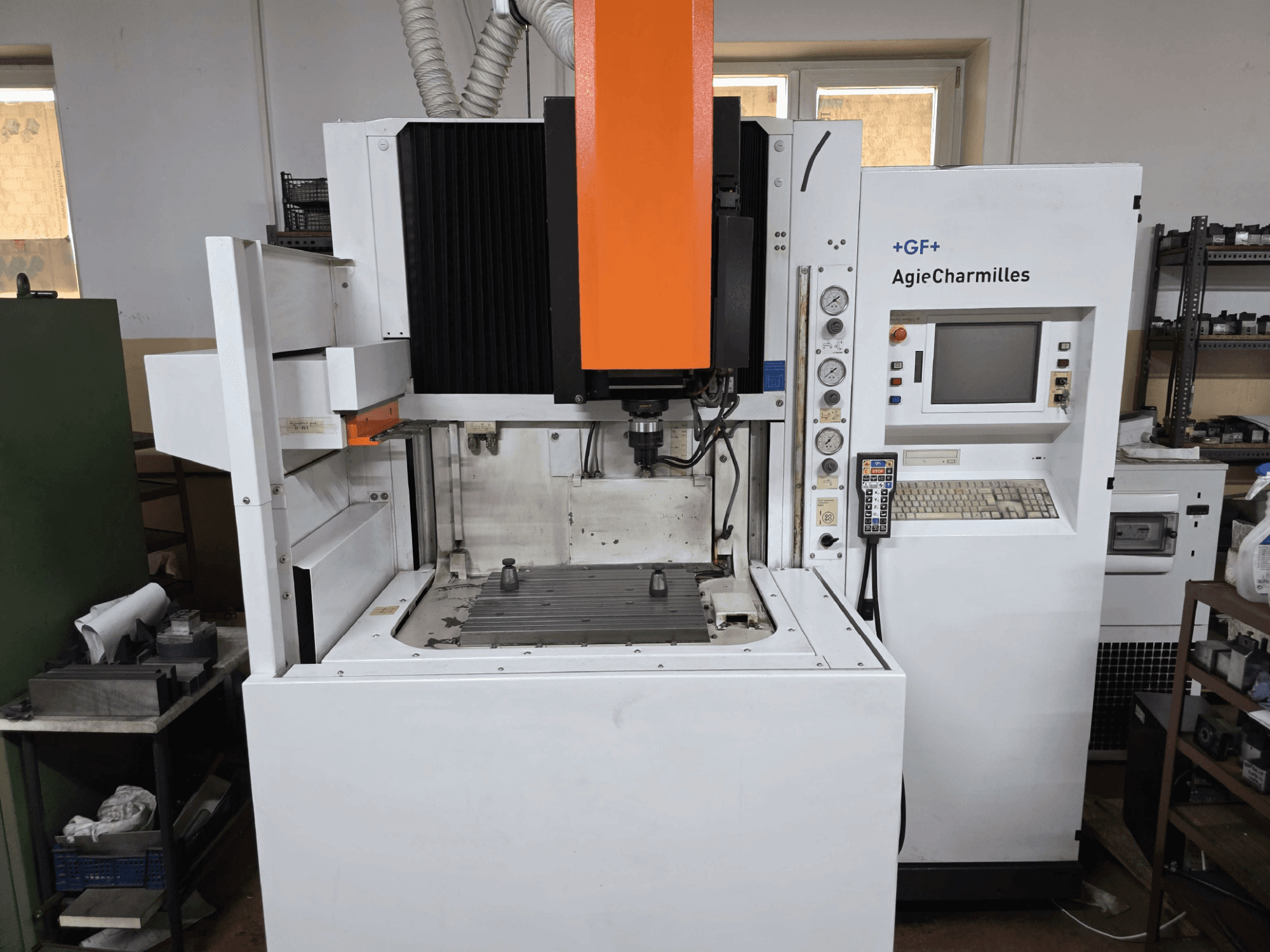 GF AgieCharmilles CNC-Maschine, Frontansicht mit auffälliger orangefarbener Spindel, digitalem Bedienfeld und montiertem Bohrtisch.