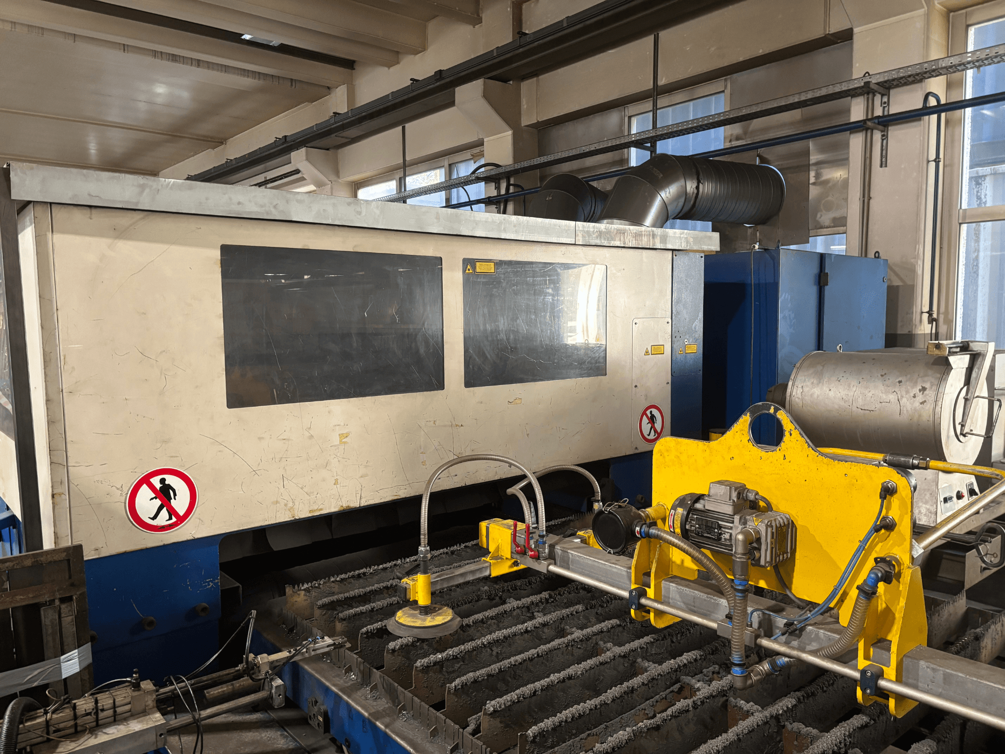 TRUMPF Trumatic L3030 CO2-Laserschneidmaschine, Frontansicht mit Darstellung der Bedienoberfläche und Details der Schneidfläche.