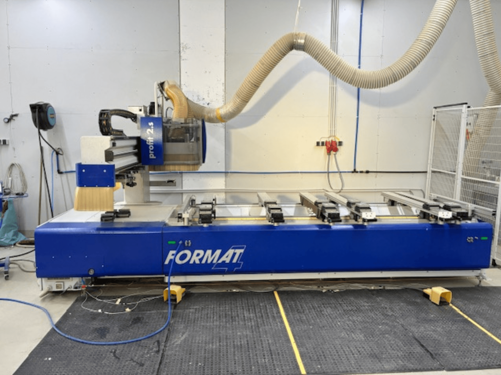Blaue FORMAT 4 CNC-Oberfräse, Modell Profit 2.5, Seitenansicht mit Schnittbereich und Staubabsaugung, auf einer Gummimatte.
