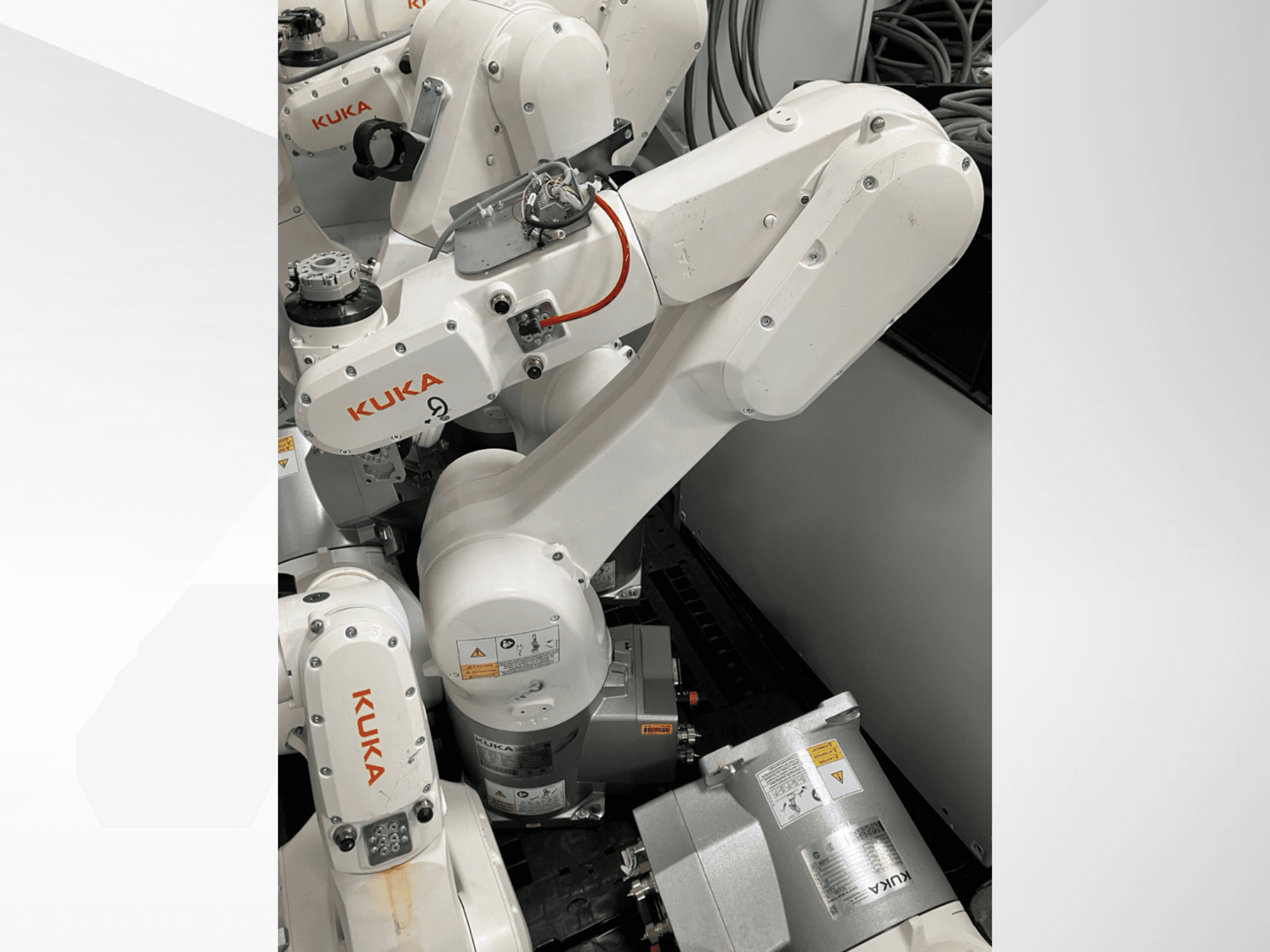KUKA KR 6 R900 CR Roboterarm, Seitenansicht; mit sichtbaren Motoren und Anschlüssen, gekennzeichneten Sicherheitswarnungen und mechanischen Armen.
