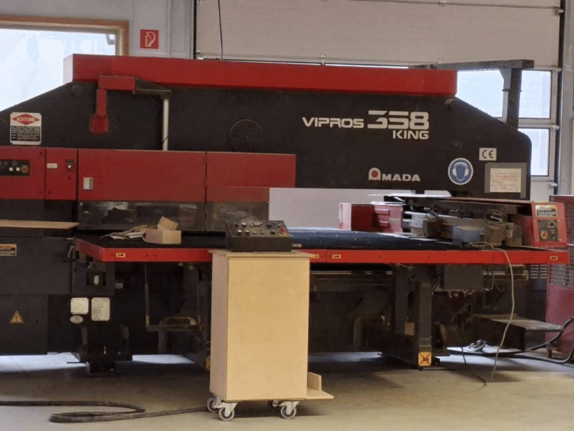 CNC-Stanzpresse AMADA VIPROS 358 KING in Seitenansicht, mit Bedienfeld und Werkzeugaufbewahrungsbereich.