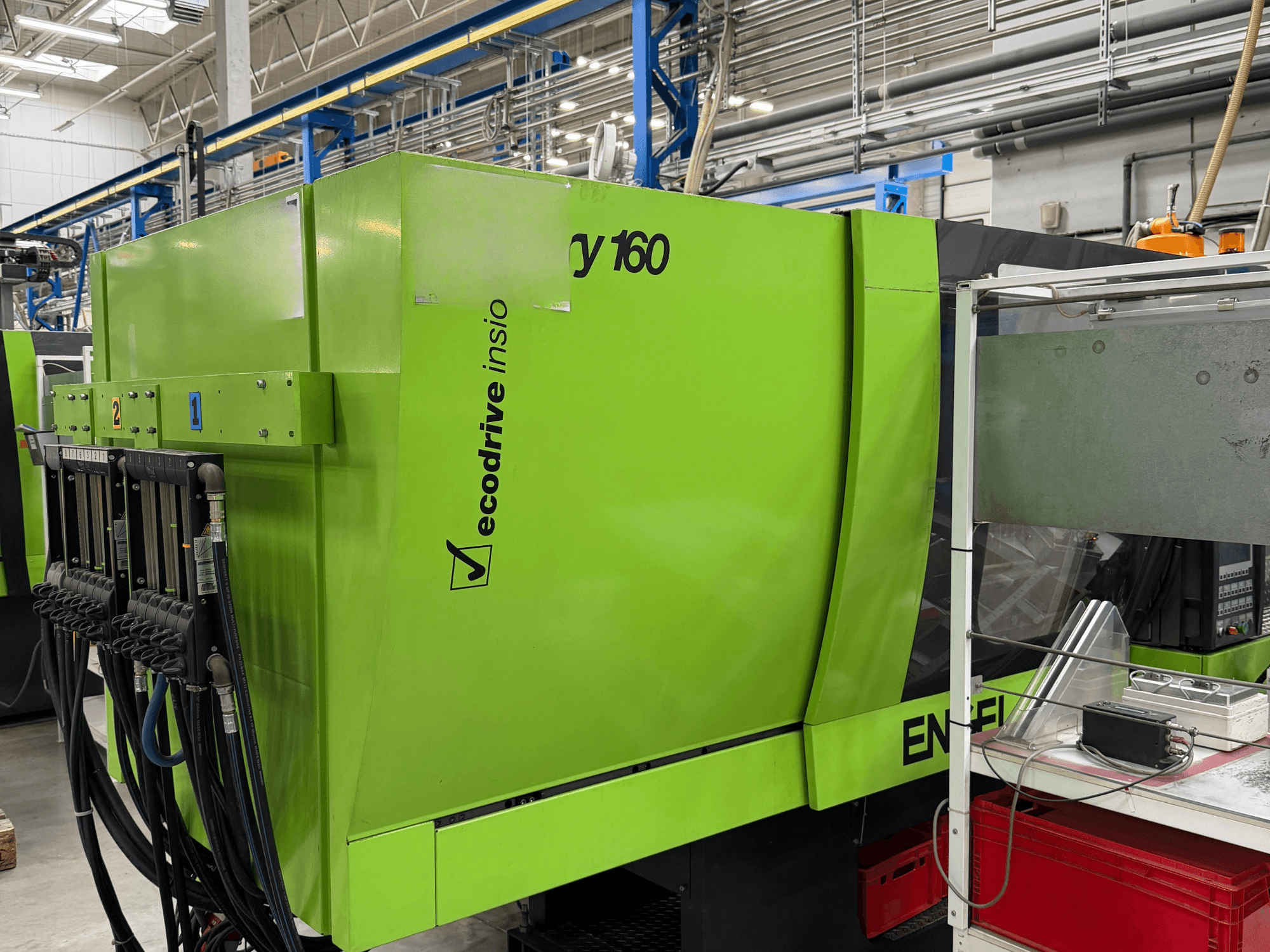 Hydraulische Spritzgießmaschine „Engel Victory 500/160 tech“ in Grün, Seitenansicht mit Bedienfeld und Ecodrive-Funktion.