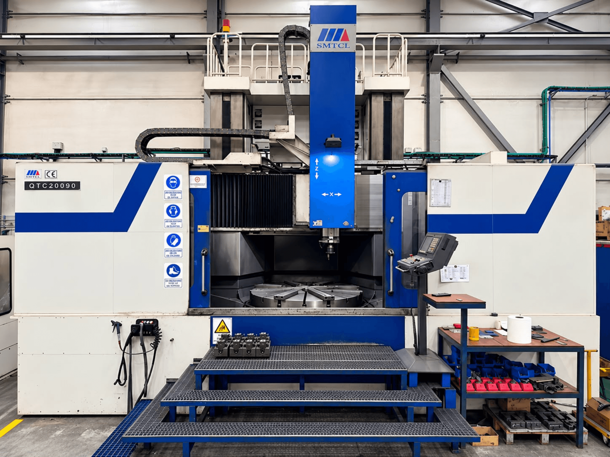 SMTCL QTC 20090 Vertikaldrehmaschine in einer Werkstatt, Vorderansicht, mit Bedienfeld und Arbeitstisch.