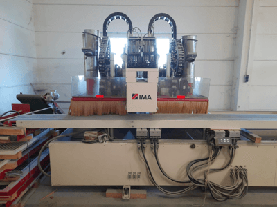 CNC-Holzbearbeitungszentrum IMA BIMA 610 V, von vorne gesehen, mit Bürsten, Bedienelementen und einem Arbeitstisch.