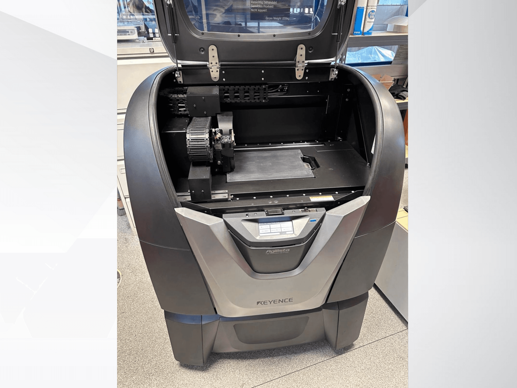 KEYENCE Agilista 3D-Drucker, Vorderansicht, zeigt die offene Oberseite, die große Bauplattform und die internen mechanischen Komponenten.