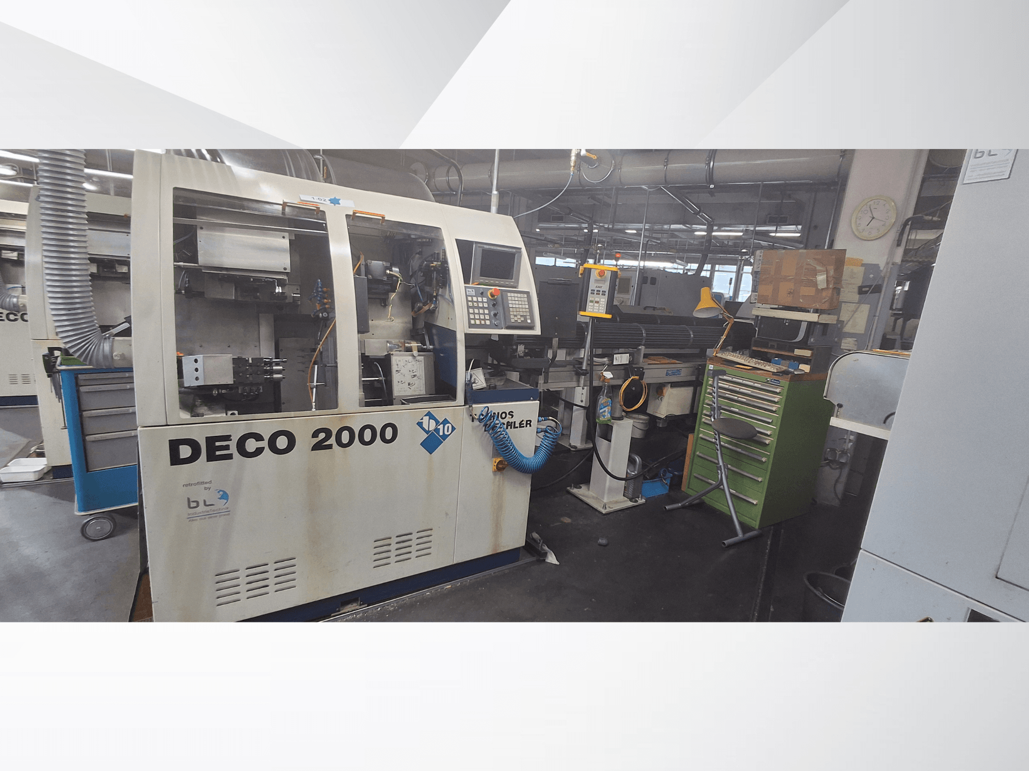 Schweizer Drehmaschine TORNOS DECO 2000-10, Vorderansicht, mit Bedienfeld und Ladebereich in einer Werkstattumgebung.
