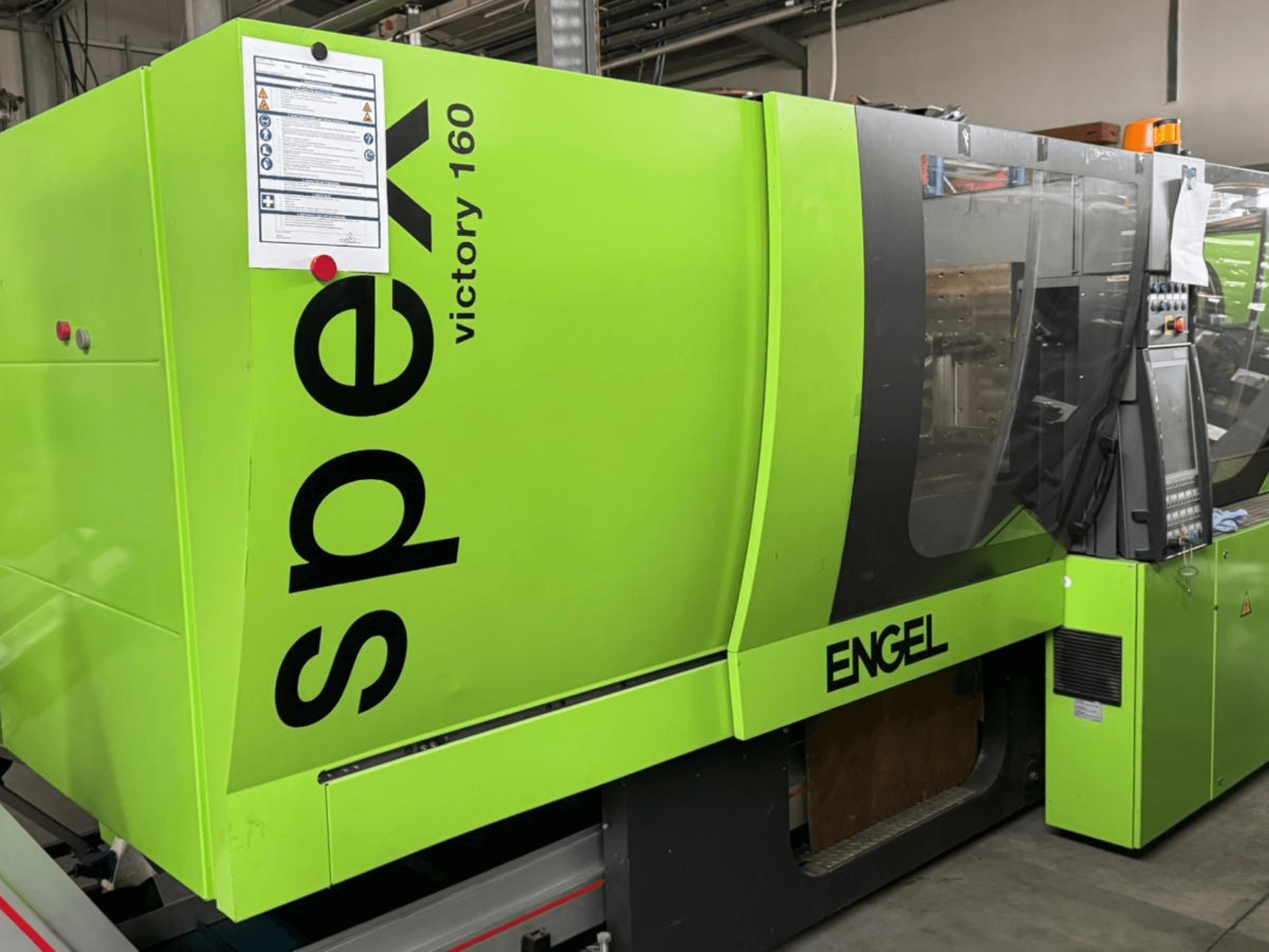Hellgrüne ENGEL Victory 160 Spritzgießmaschine, Seitenansicht, Bedienfeld und Sicherheitsschilder sichtbar.