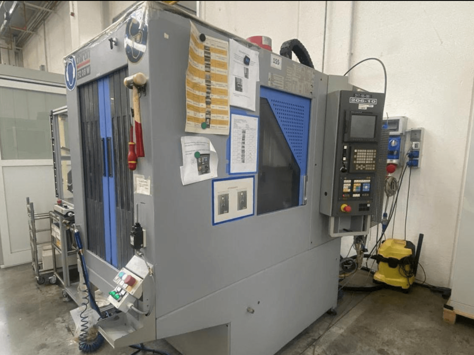 CNC-Maschine von Shin Lin, Vorderansicht, mit Bedienfeld, Bedientasten und Sicherheitshinweisen.