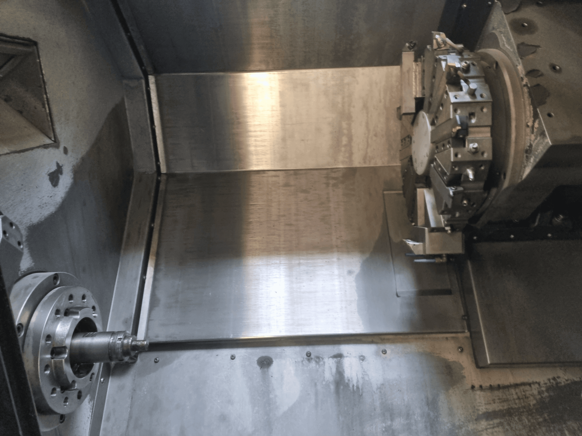 Innenansicht einer CNC-Drehmaschine mit einer rotierenden Spindel und einer Metallarbeitsfläche, die industrielle Präzisionstechnik zeigt.