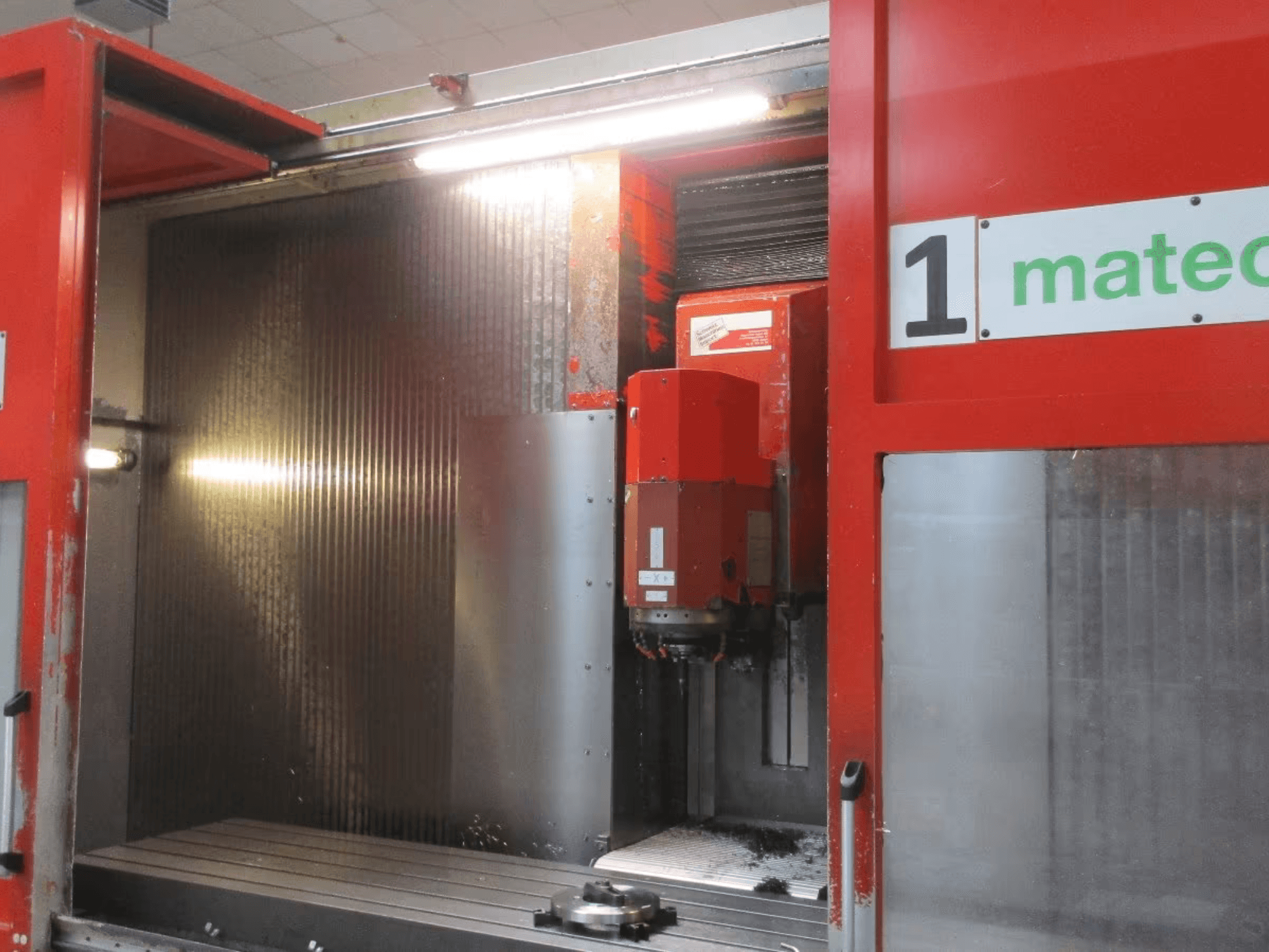 Vorderansicht des CNC-Vertikal-Bearbeitungszentrums Matec 30 HV mit sichtbarem Schneidwerkzeug, Metalloberfläche und Maschinendetails.