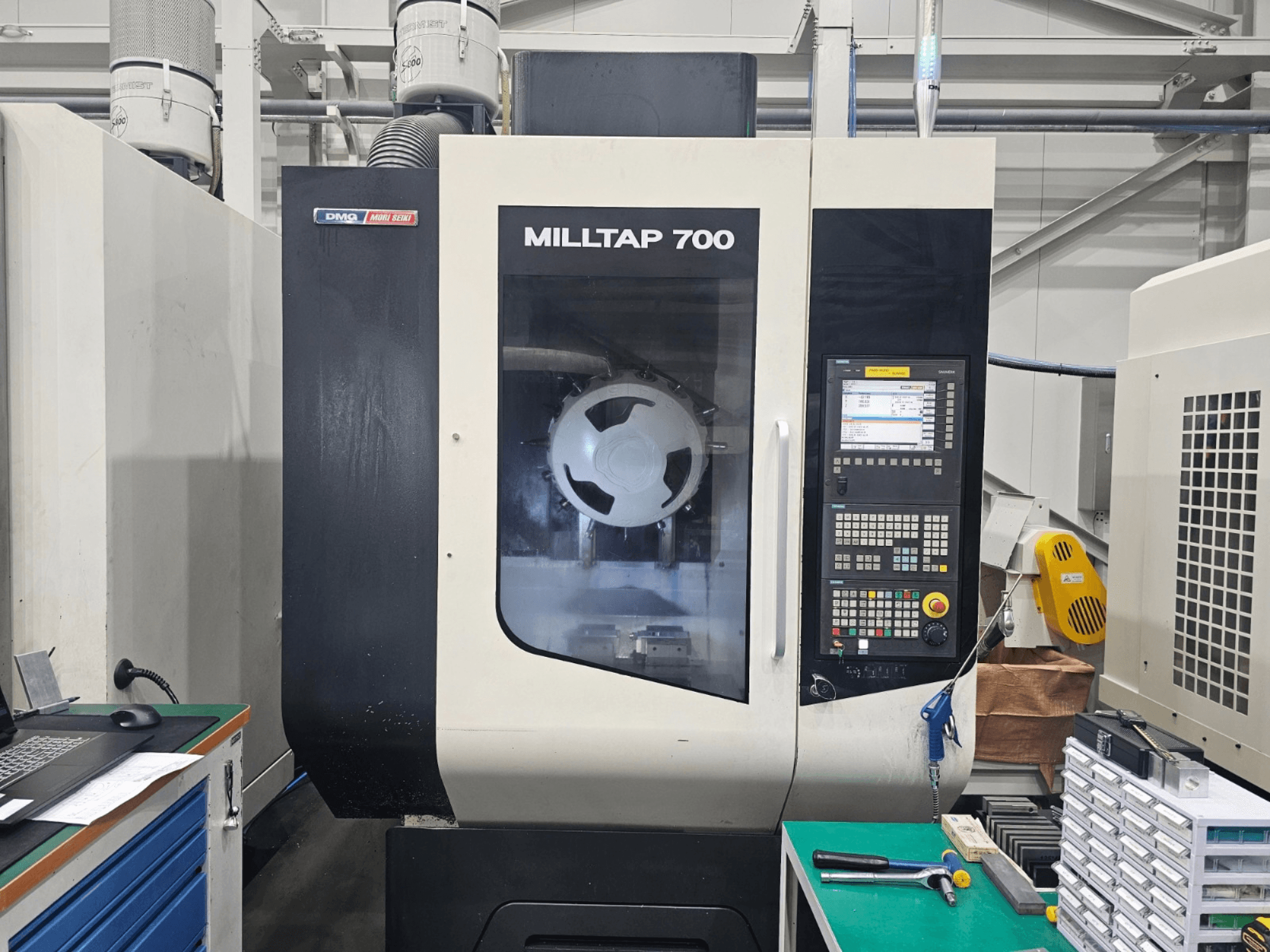 Vertikales Bearbeitungszentrum DMG MORI MILLTAP 700, Vorderansicht, mit Details zum Bedienfeld, zur Spindel und zum Arbeitsbereich.