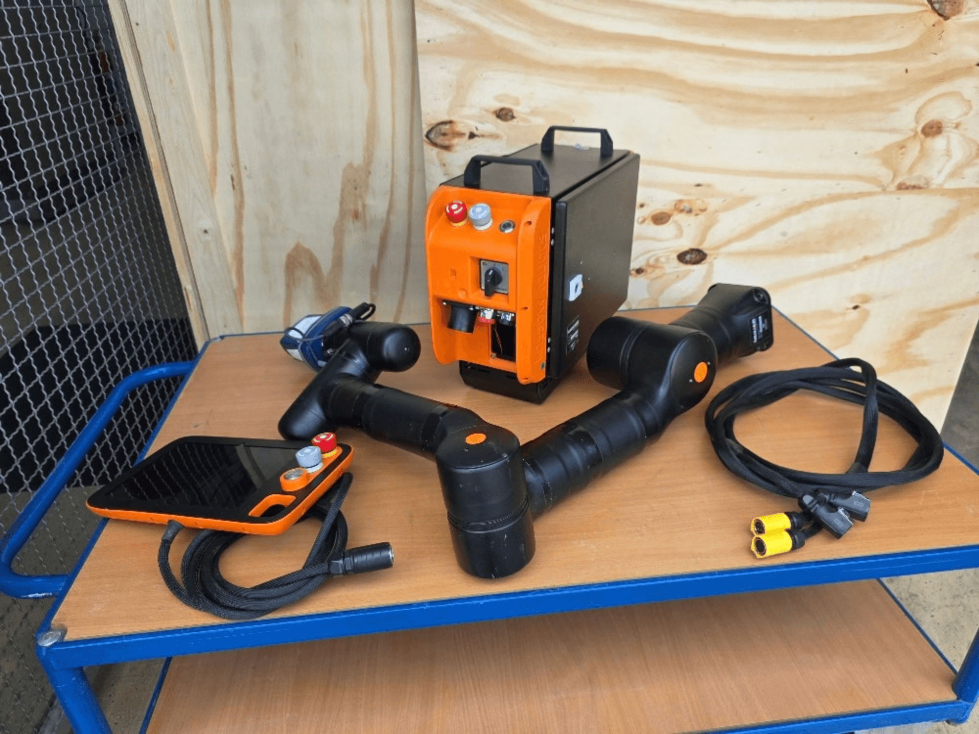 KASSOW ROBOTS KR810-Kollaborationsroboter, Vorderansicht, einschließlich Steuerung, Kabel und Anschlüsse auf einem Holztisch.
