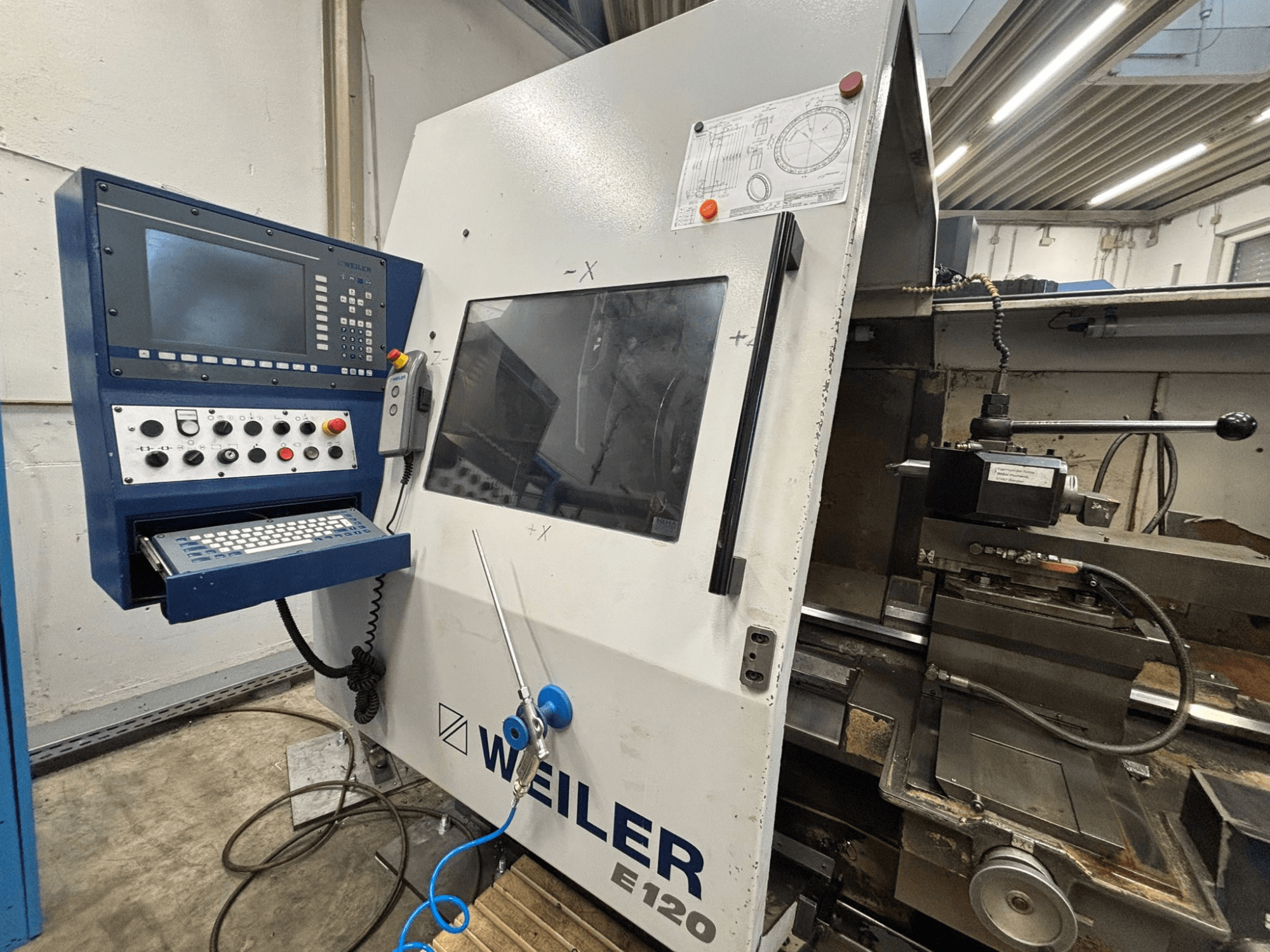Bedienfeld und Schnittstelle der Weiler E-120 CNC-Maschine, Frontansicht mit sichtbaren Tasten, Bildschirm und Bedienelementen.
