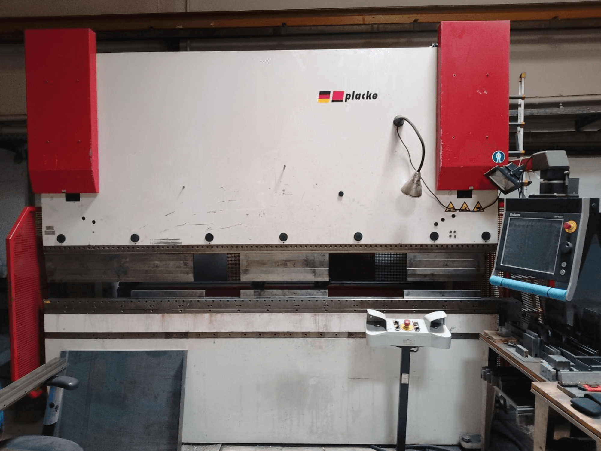 Abkantpresse PLACKE QPB-4 150/3100, Vorderansicht mit Bedienfeld, roten Armen und Biegebereich aus Metall.