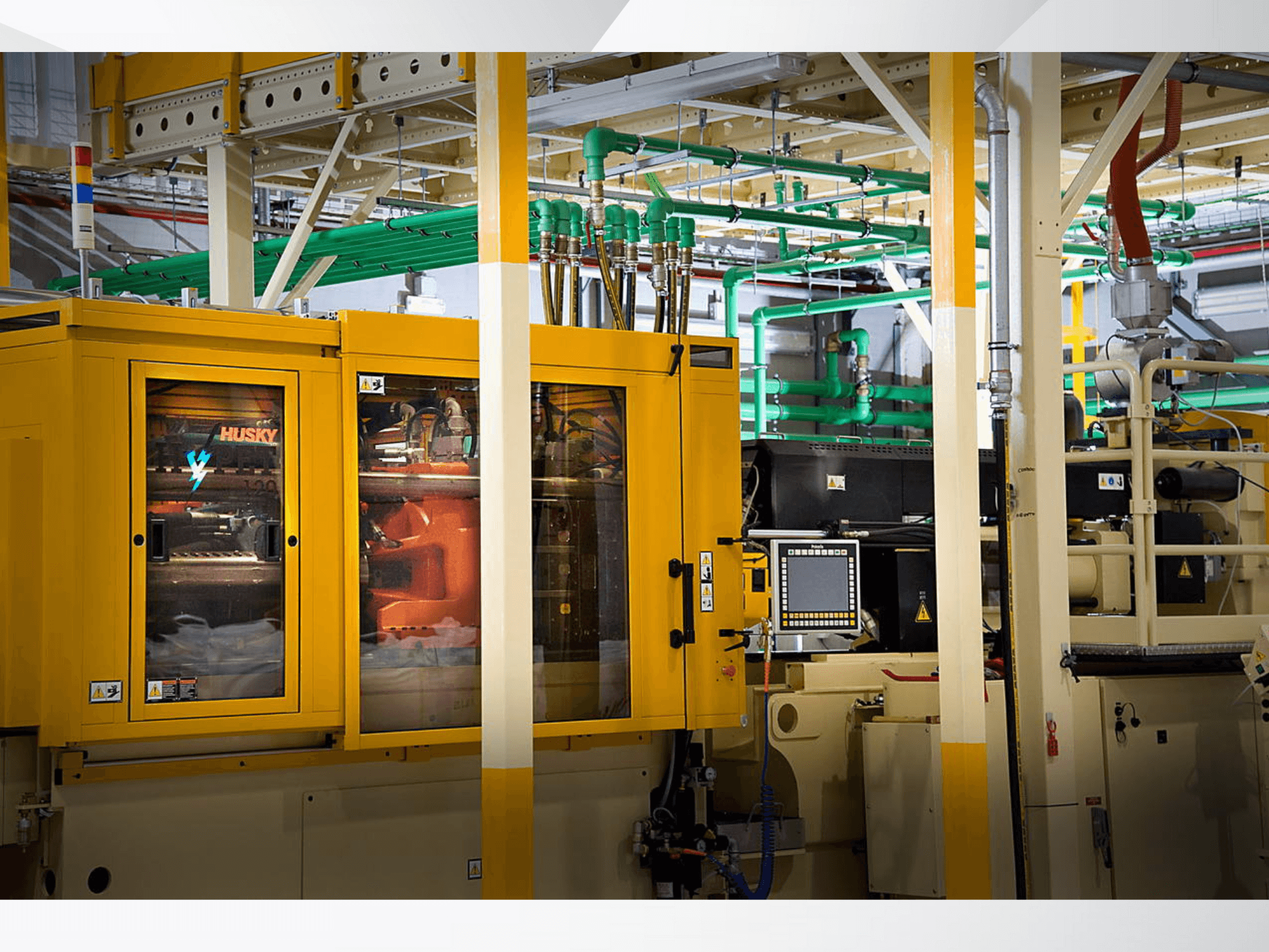 Husky-Industriemaschine in Gelb, Frontansicht mit Bedienfeld und internen Mechanismen vor einem Fabrikhintergrund.