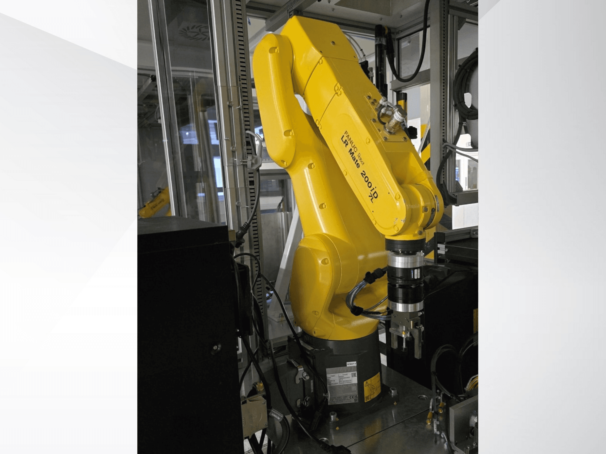 Gelber Fanuc LR Mate 200iD-Roboterarm in der Seitenansicht mit einem Greifer und verschiedenen Kabeln.