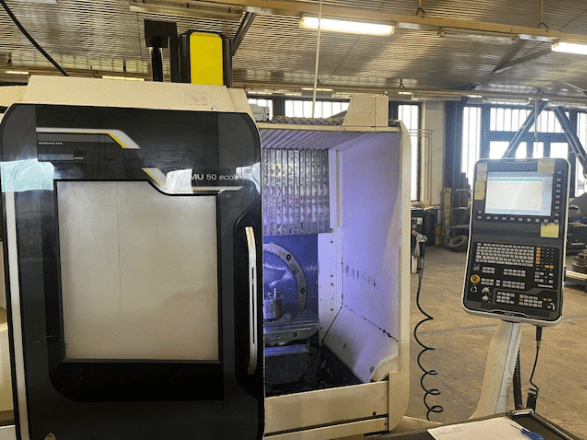 DMU 50 eco Fräsmaschine in der Frontansicht mit Bedienfeld, Werkzeughalter und Arbeitsbereich.