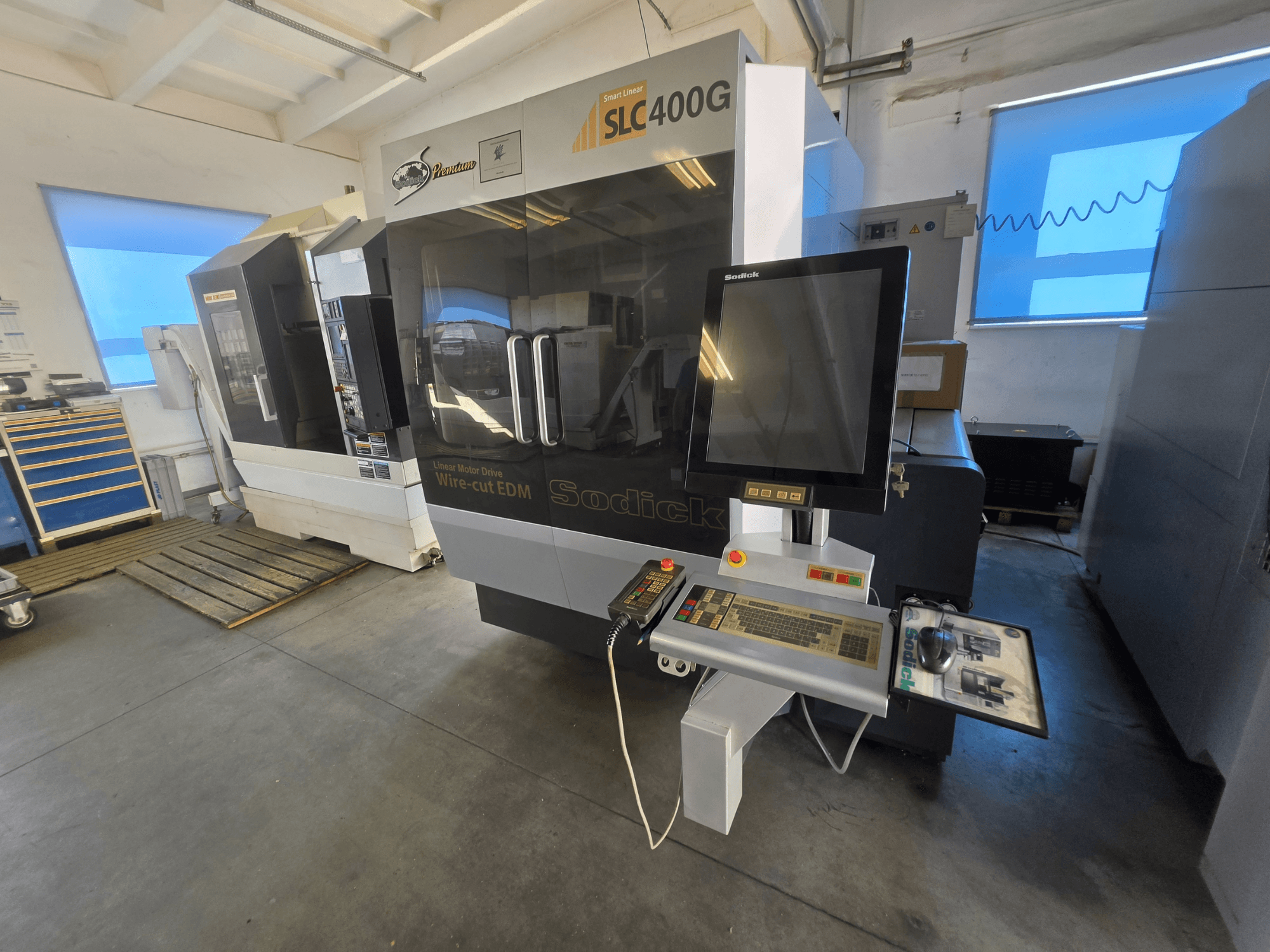 Sodick SLC400G Drahterodiermaschine, Vorderansicht mit Bedienfeld und Touchscreen-Display in einer Werkstattumgebung.