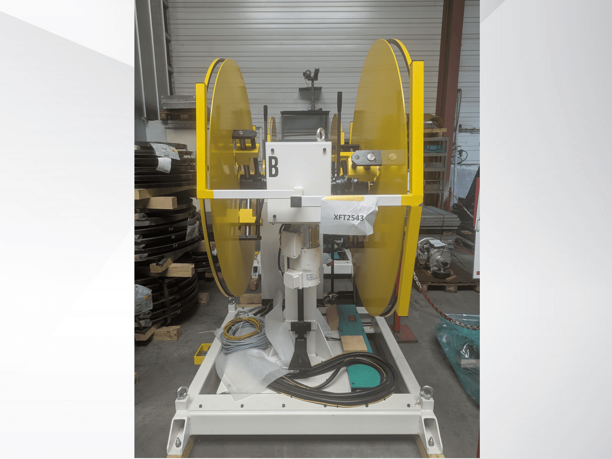 Gelbe Kreissägeblätter, montiert auf einem weißen Maschinensockel, Vorderansicht; Modell XFT2543, mit sichtbarer Verkabelung und Komponenten.