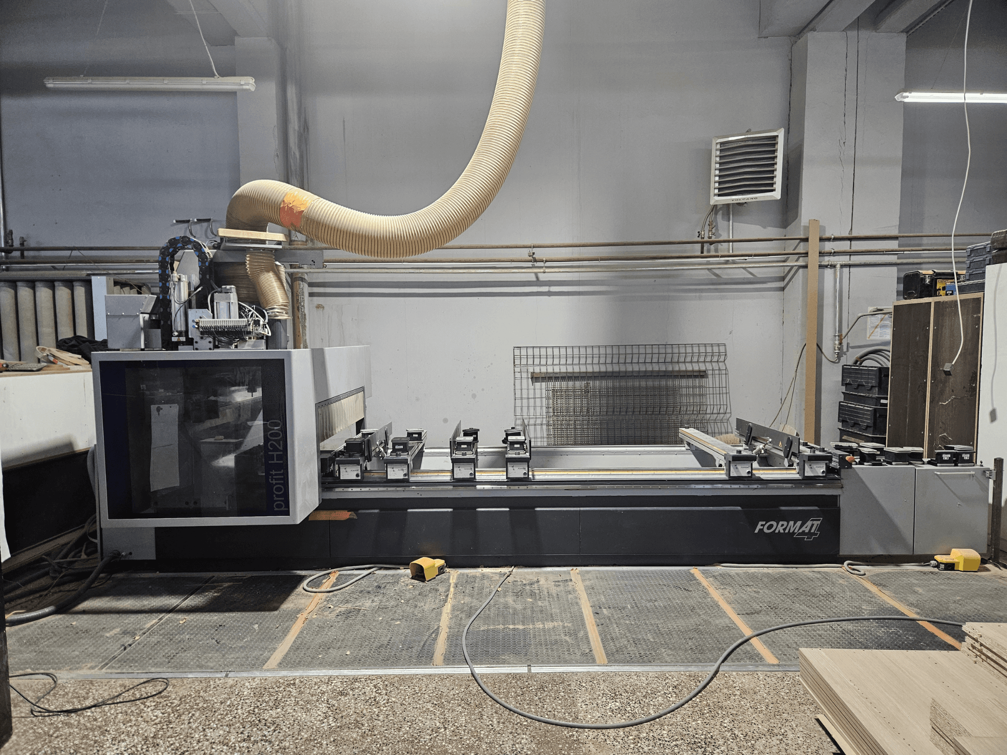 Eine FORMAT profit H200 CNC-Maschine in einer Werkstatt, Seitenansicht, mit Arbeitsfläche und Staubabsaugung.