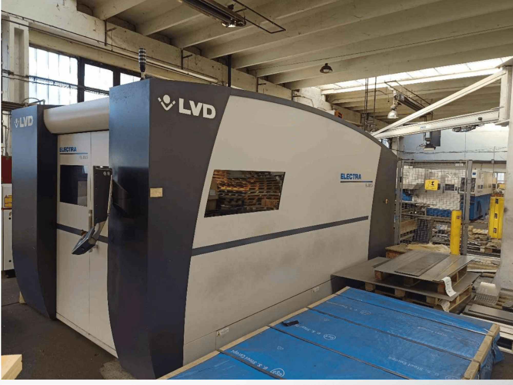 LVD Electra Laserschneidmaschine in der Seitenansicht, mit einem schlanken Design und einem Bedienfeld an der Tür, aufgestellt in einer Werkstatt.