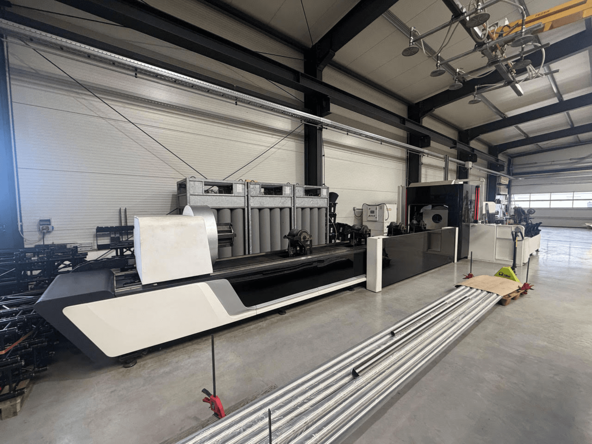 Bodor X2260 Rohrschneidemaschine in einer Werkstatt, Seitenansicht mit Maschinenkörper und Metallrohren auf dem Boden.