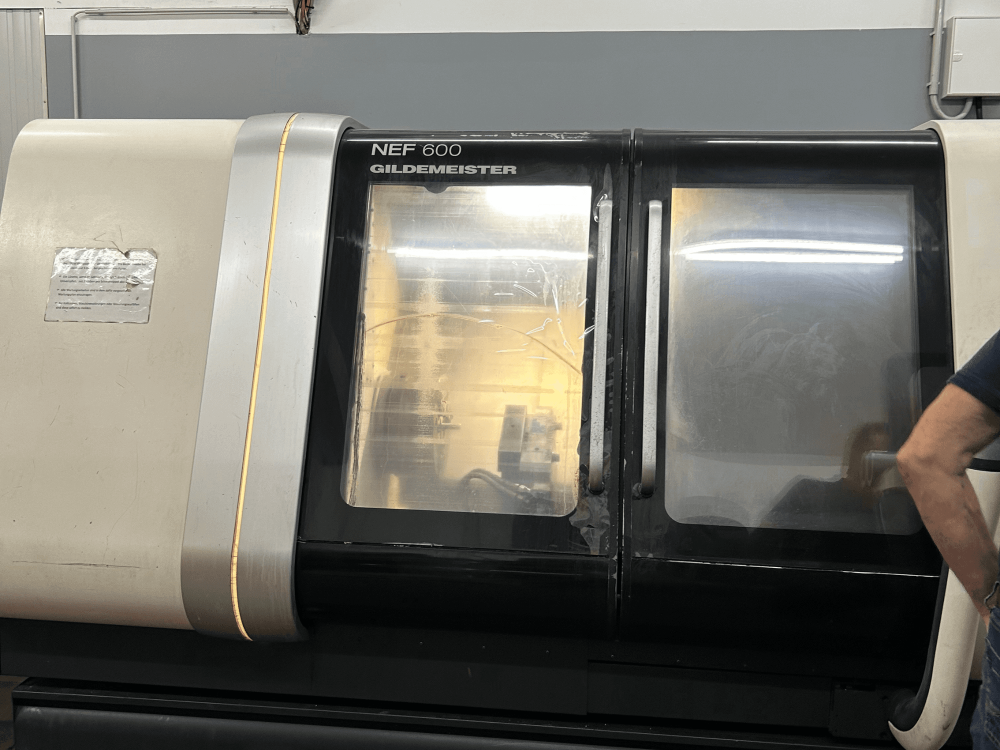Horizontal-Drehmaschine DMG NEF 600, Vorderansicht, mit glänzender Oberfläche und großen Sichtfenstern.