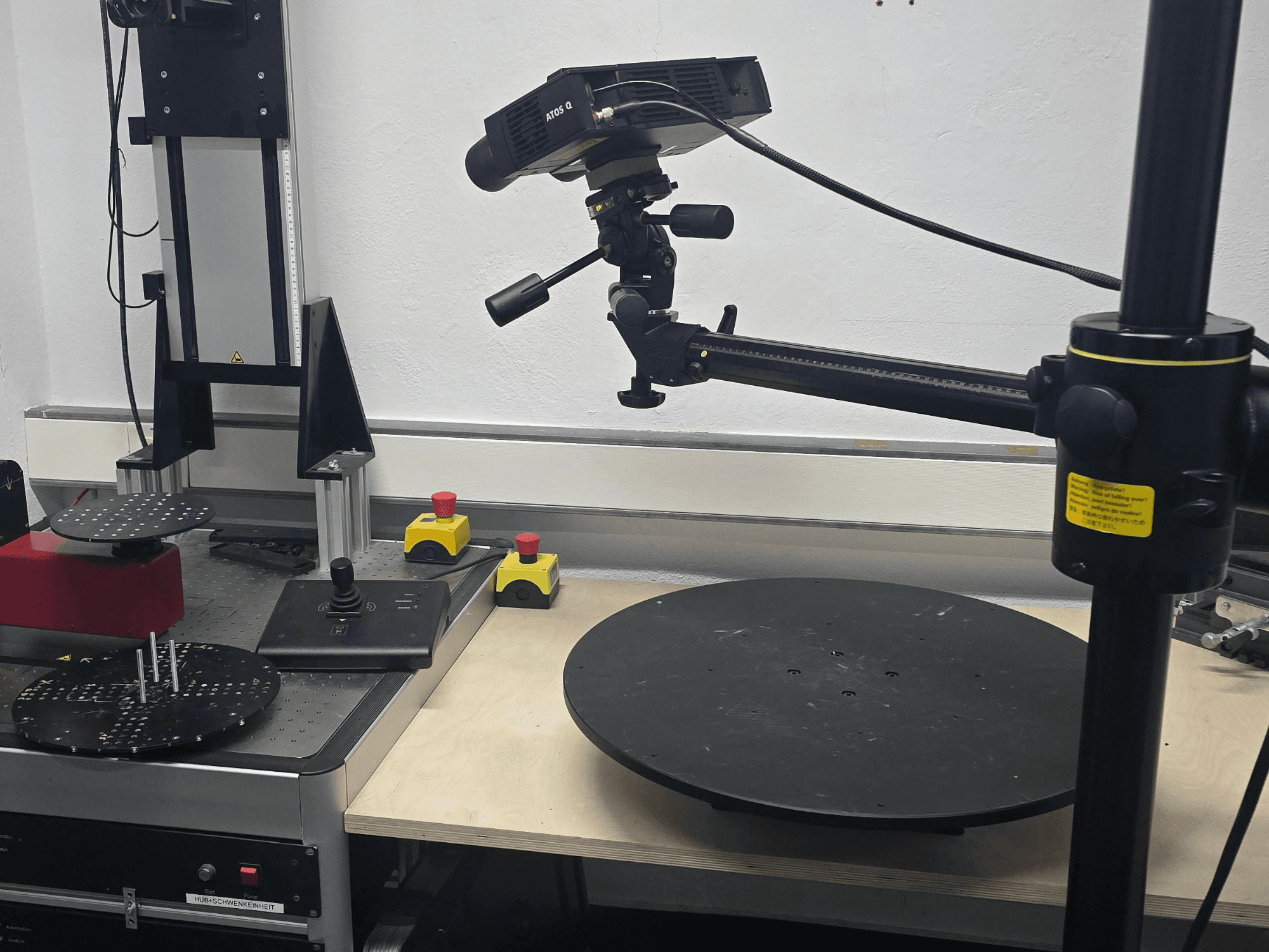 Vorderansicht der optischen Messmaschine ZEISS ATOS Q 12M mit Abtastkopf, Bedienfeld und drehbarer Rundtischplattform.