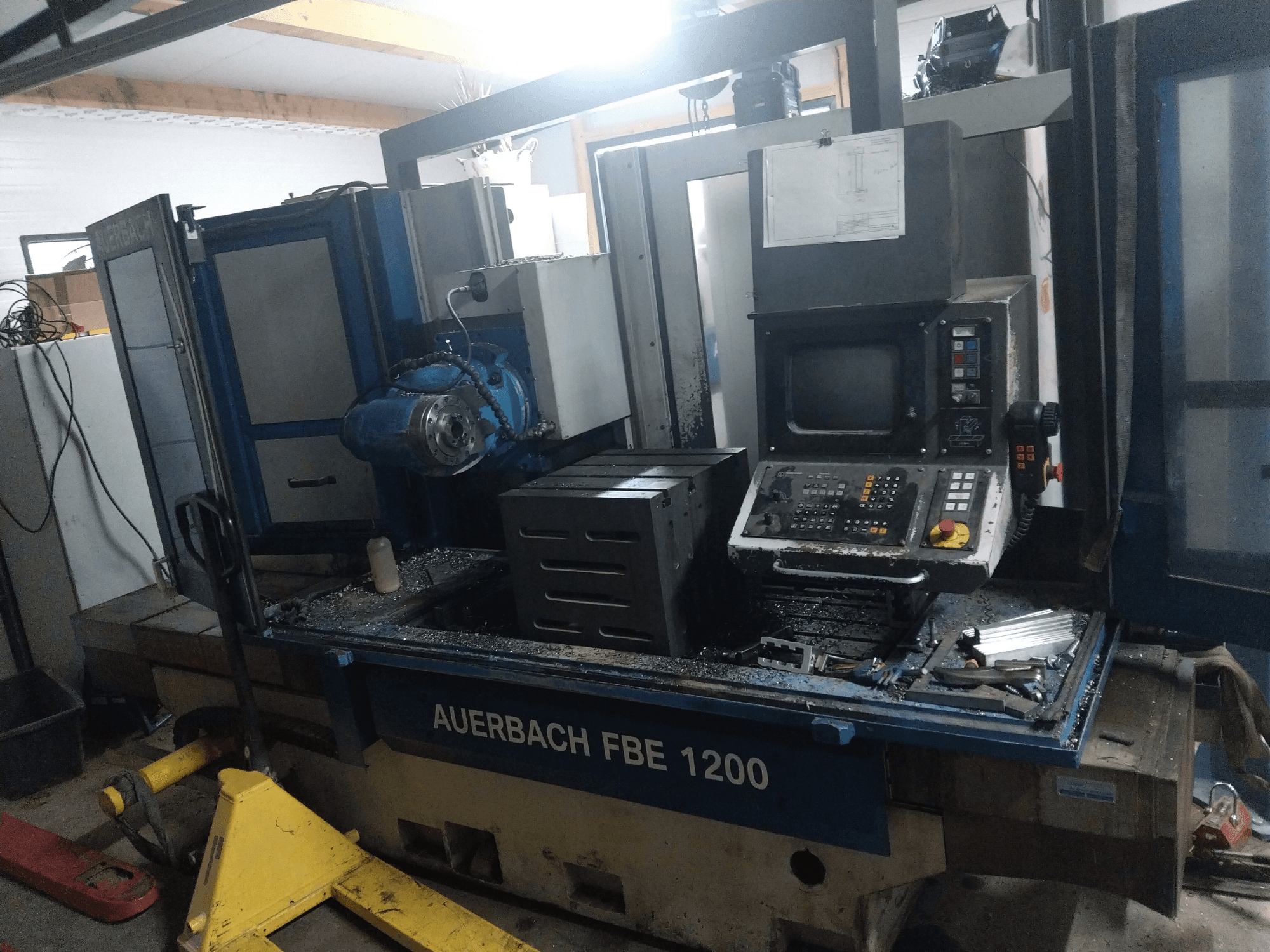 Auerbach FBE 1200 Metallbohrmaschine, Vorderansicht, mit Bedienfeld, Motor und Metallspänen auf der Arbeitsfläche.